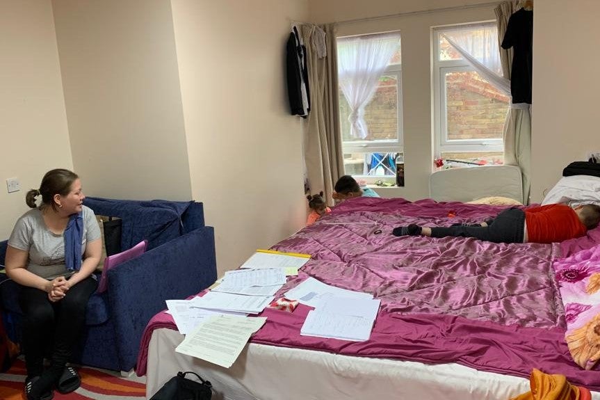 A mother watches her two children in a hotel room 