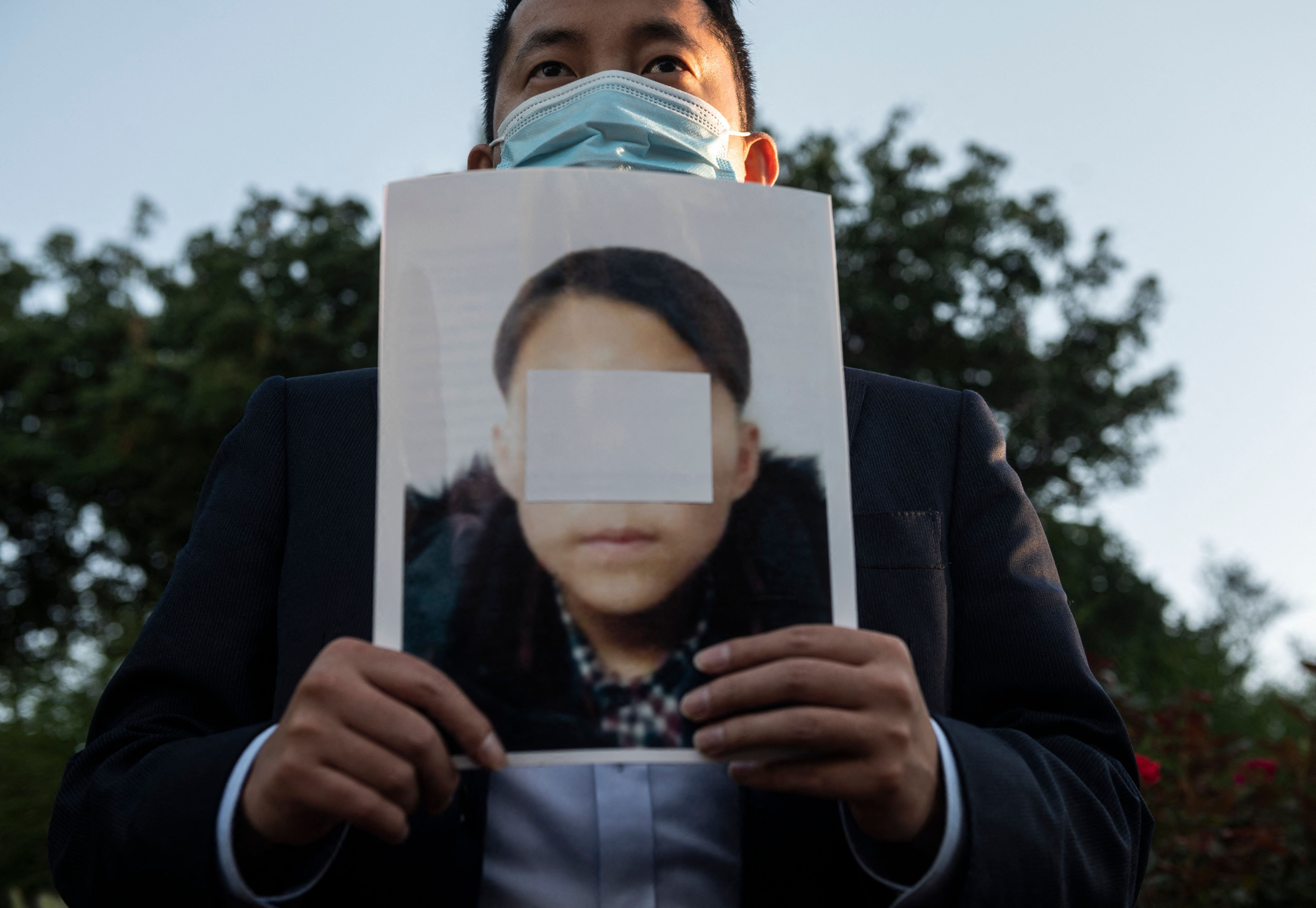 社運人士手持據稱為年輕北韓難民的相片在中國駐美大使館外示威，呼籲中國國家主席習近平允許在華被捕北韓人安全通過，美國華盛頓特區，2021年9月24日。