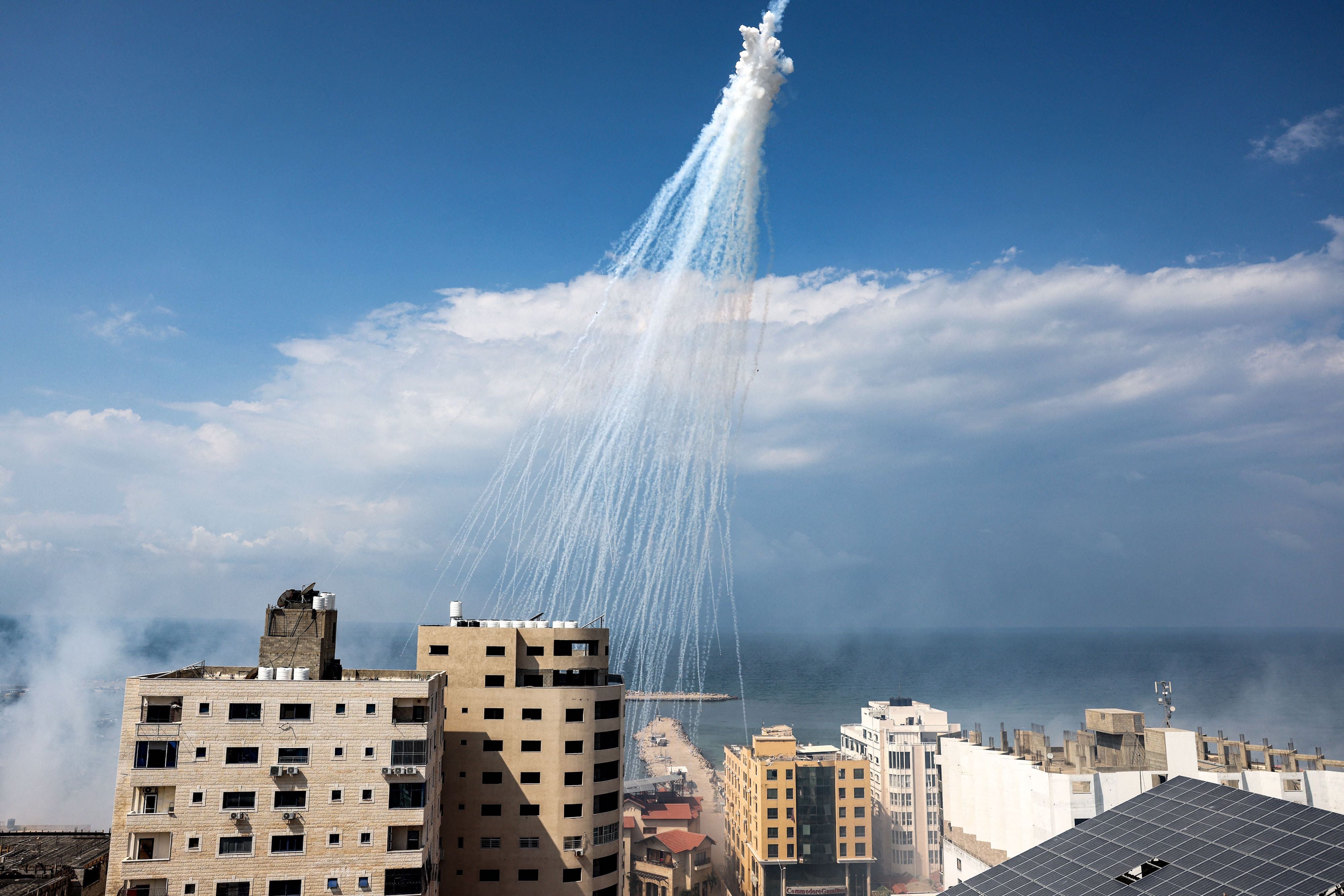 空中爆炸的白磷彈向加沙市港口周遭散落，2023年10月11日。