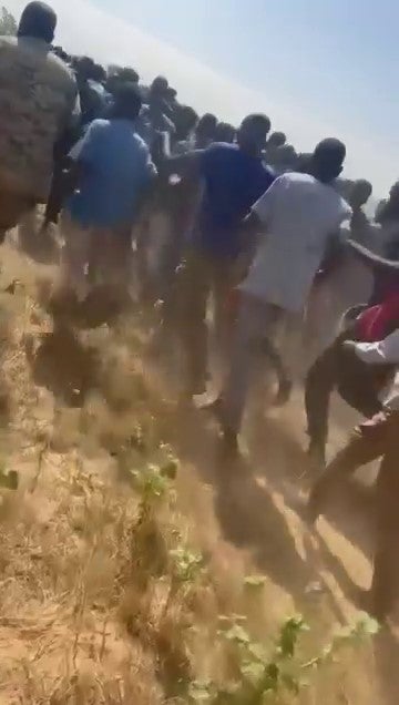 A large group of men are made to run toward the El Geneina Airport, east of Ardamata. © 2023 Private.