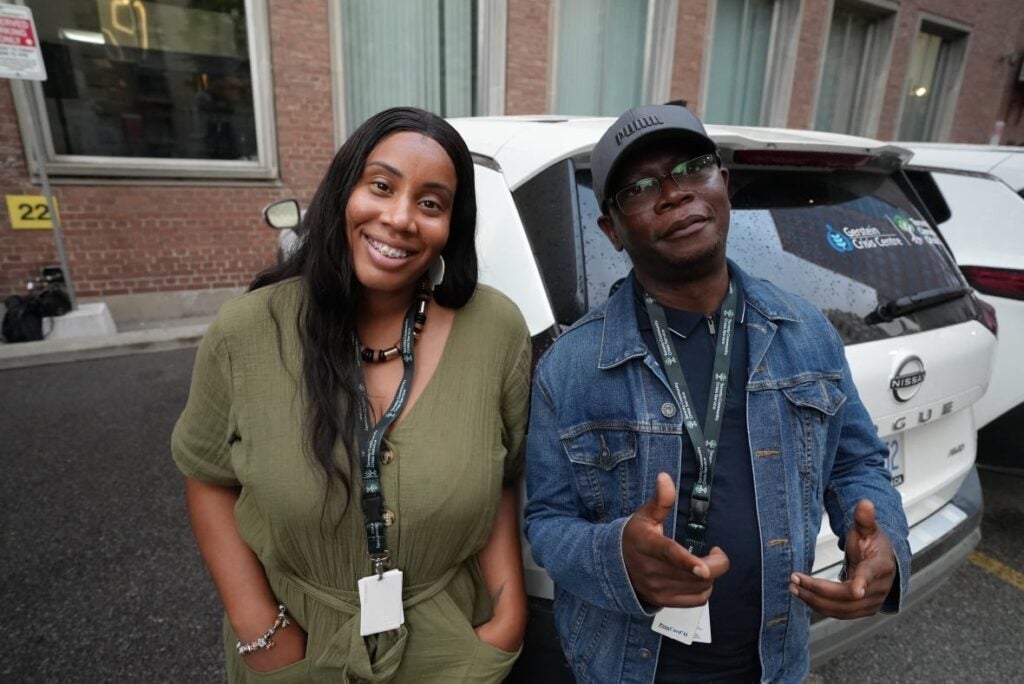 A man and woman stand in front of a crisis vehicle