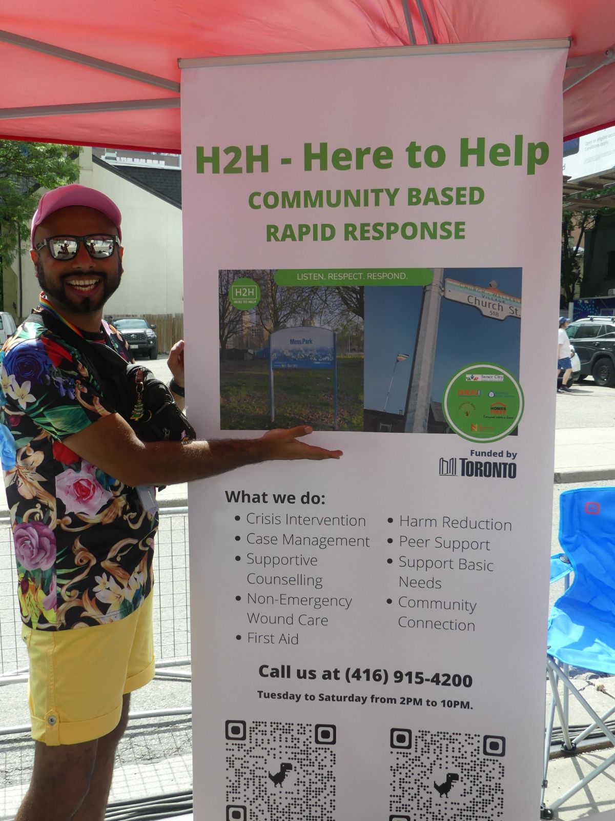 Abhi, a Gerstein crisis worker, shows one of the centre’s informational posters at Pride 2023 in Toronto