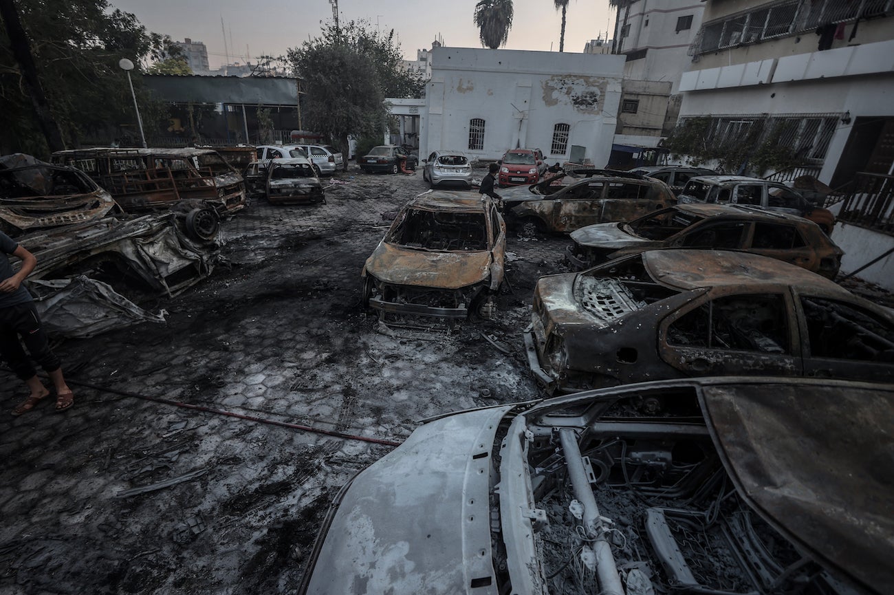 Pemandangan udara halaman Rumah Sakit al-Ahli. Sebuah ceruk terlihat di jalur antara dua area lanskap. Kerusakan akibat kebakaran terlihat pada mobil-mobil di tempat parkir yang bersebelahan, Kota Gaza, 17 Oktober 2023. 