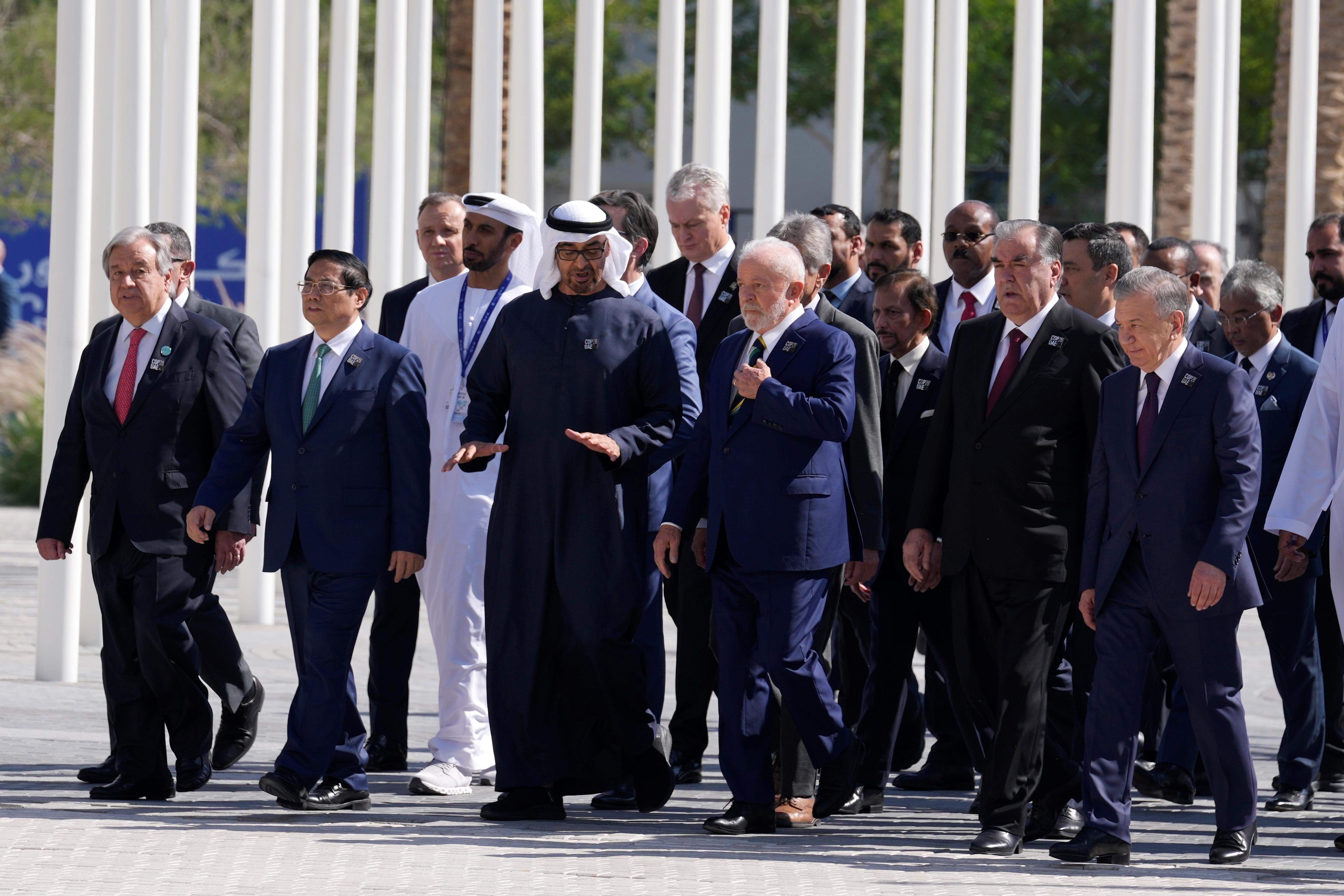 United Nations Secretary-General Antonio Guterres, left, and Brazil President Luiz Inacio Lula da Silva, center, walk with other dignitaries after posing for a group photo at the COP28 U.N. Climate Summit in Dubai, United Arab Emirates, December 1, 2023.