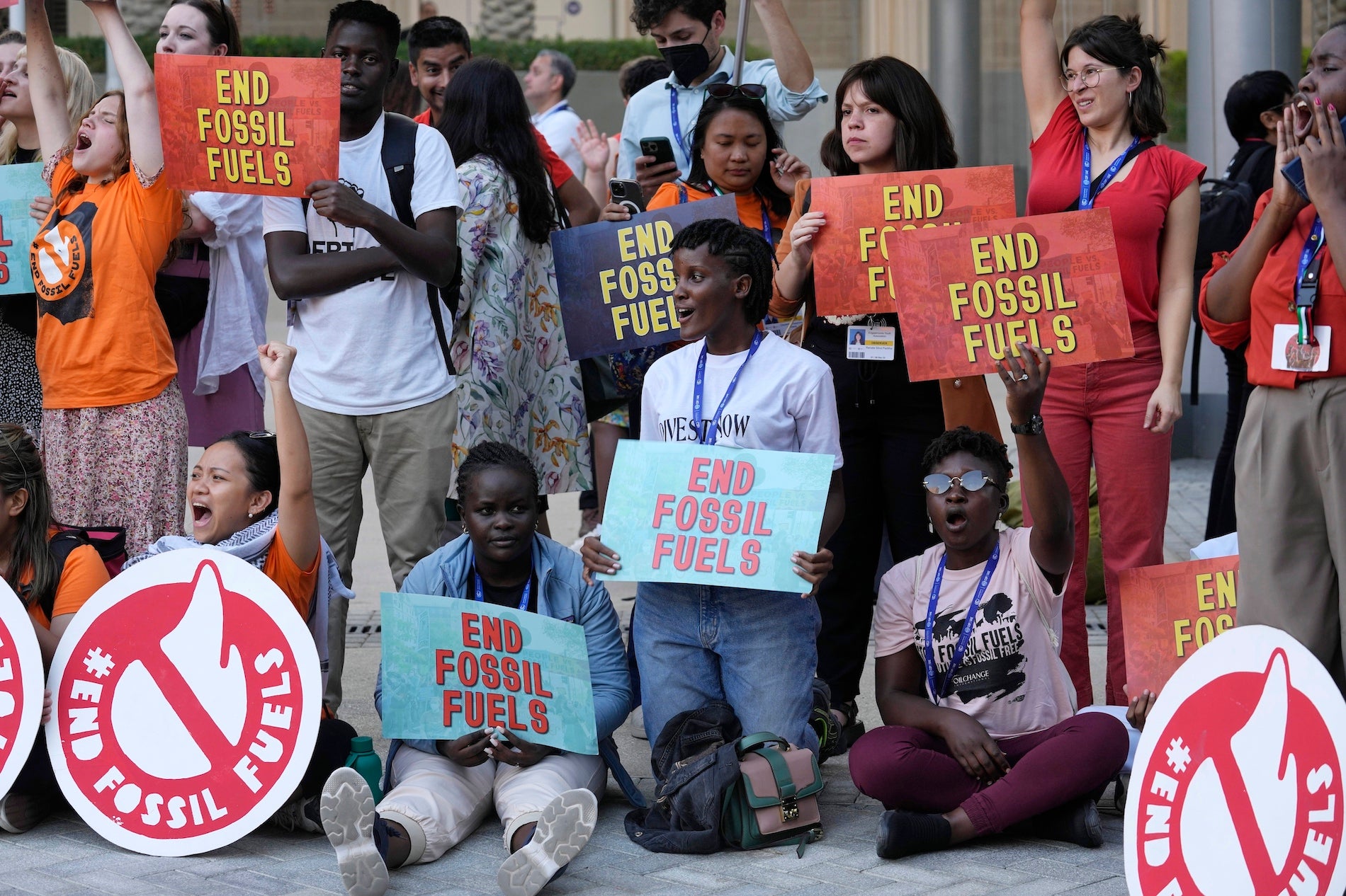 Plusieurs activistes dont l’Ougandaise Vanessa Nakate, à genoux vers le centre de la photo, tenaient des pancartes appelant à la fin de l’exploitation de combustibles fossiles lors de la conférence COP28 de l’ONU sur le climat à Dubaï, aux Émirats arabes unis, le 5 décembre 2023.