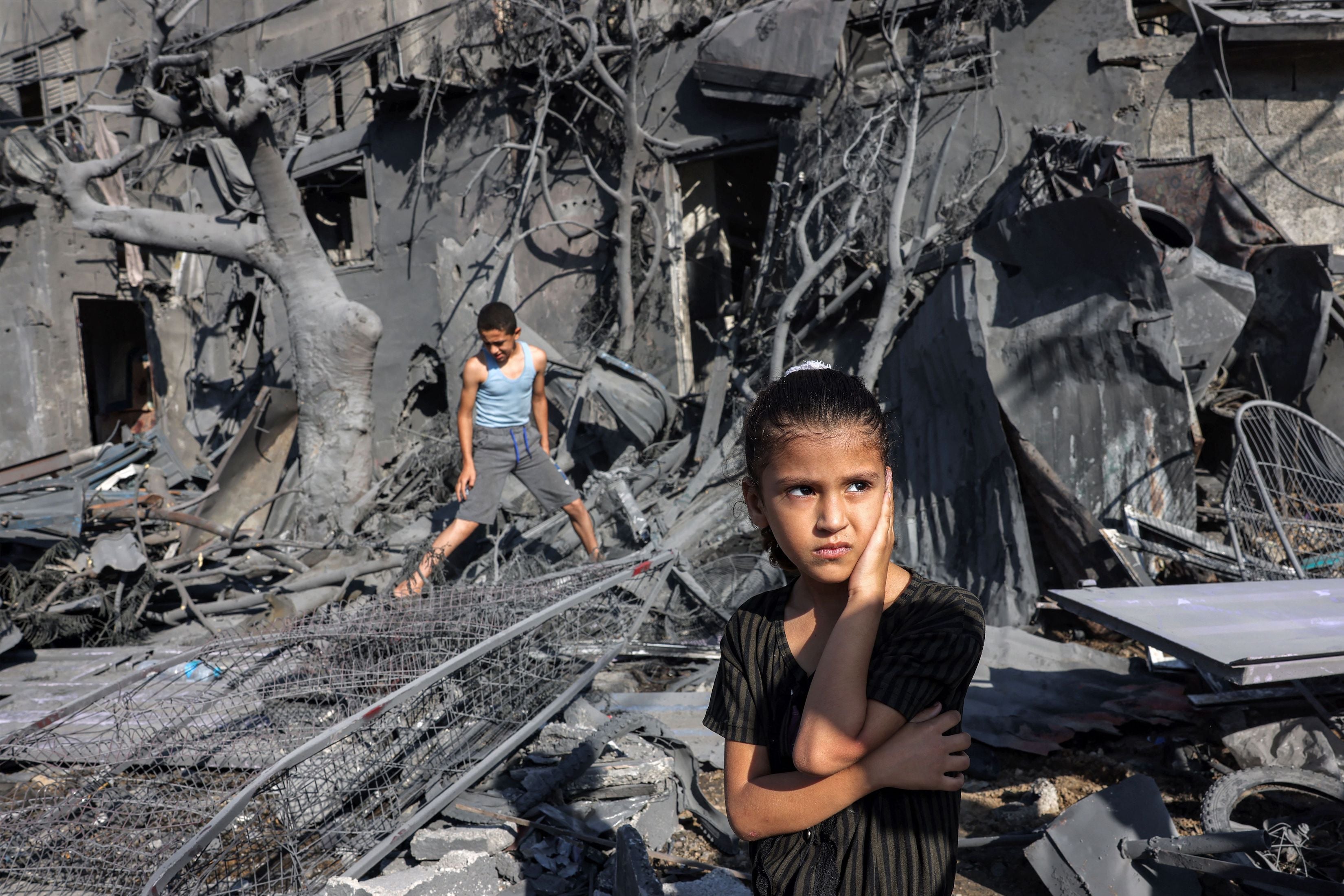 A girl stands by the rubble outside a building hit by Israeli bombardment in Rafah in the southern Gaza Strip on October 31, 2023. 