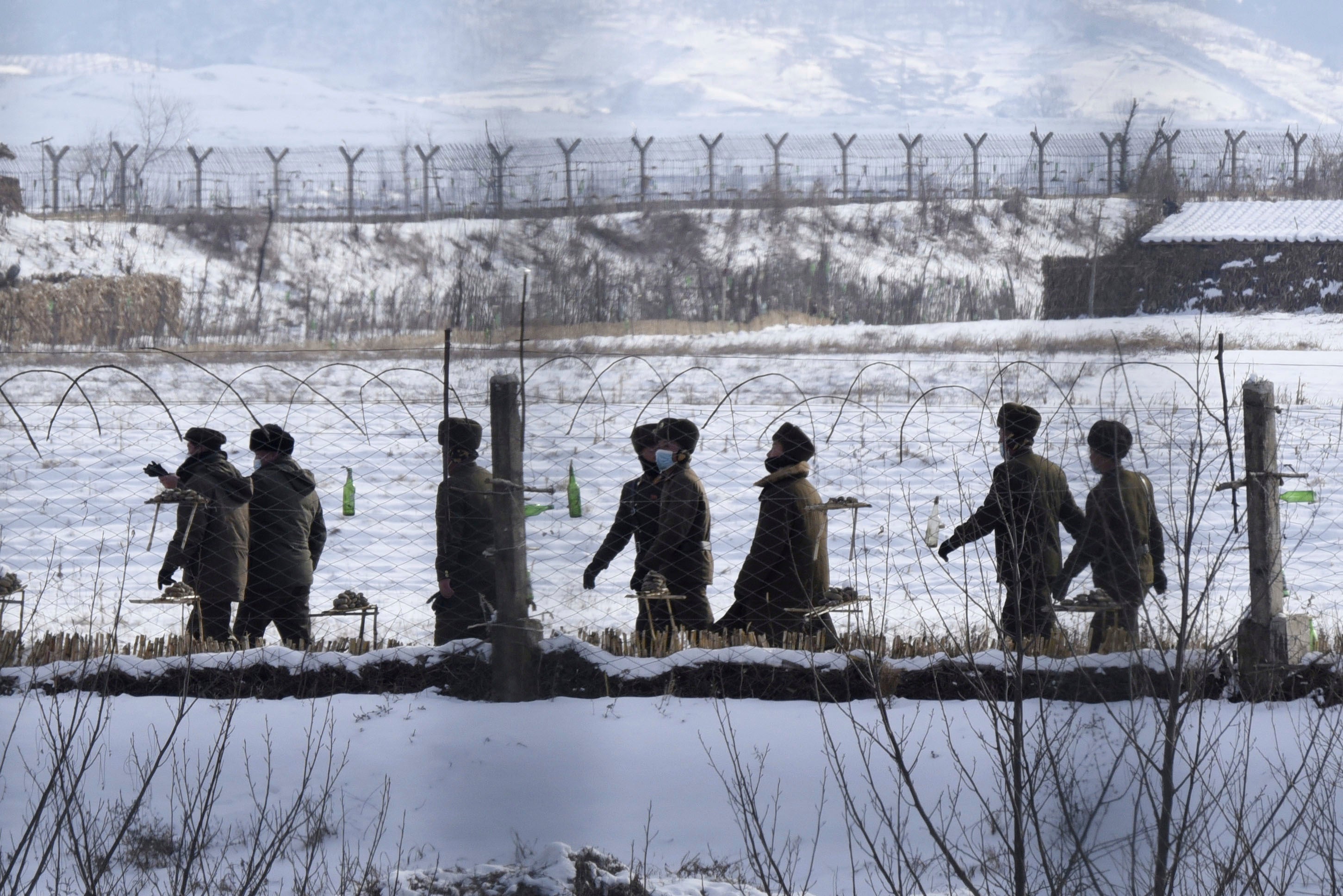 Ein am 22. Dezember 2022 in der chinesischen Stadt Dandong aufgenommenes Foto zeigt nordkoreanische Soldaten, die an einem Flussufer im Grenzbezirk Uiju patrouillieren.