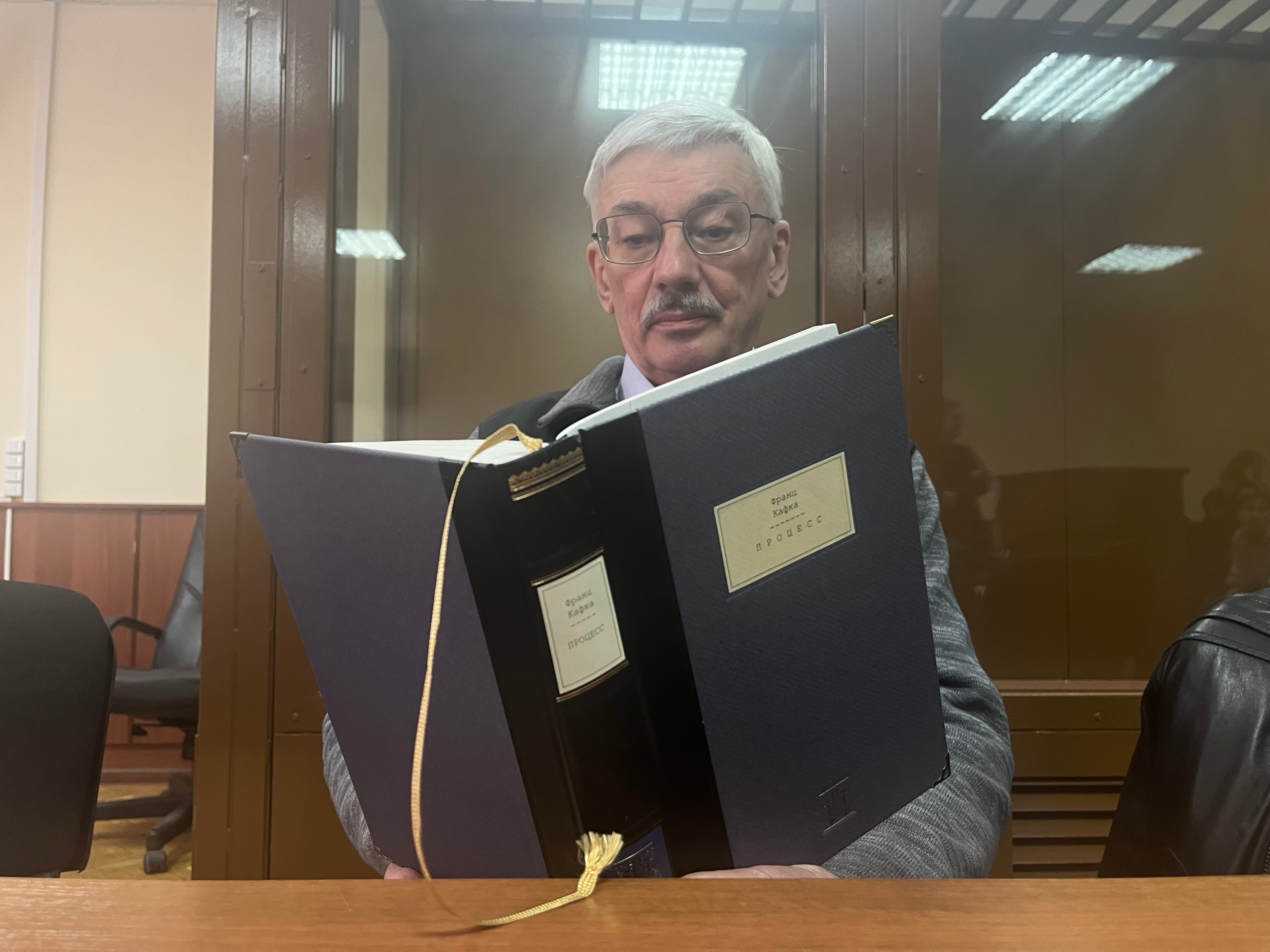 Le défenseur russe des droits humains Oleg Orlov lit le roman « Le Procès » de Franz Kafka lors de son procès à Moscou, le 26 février 2024.