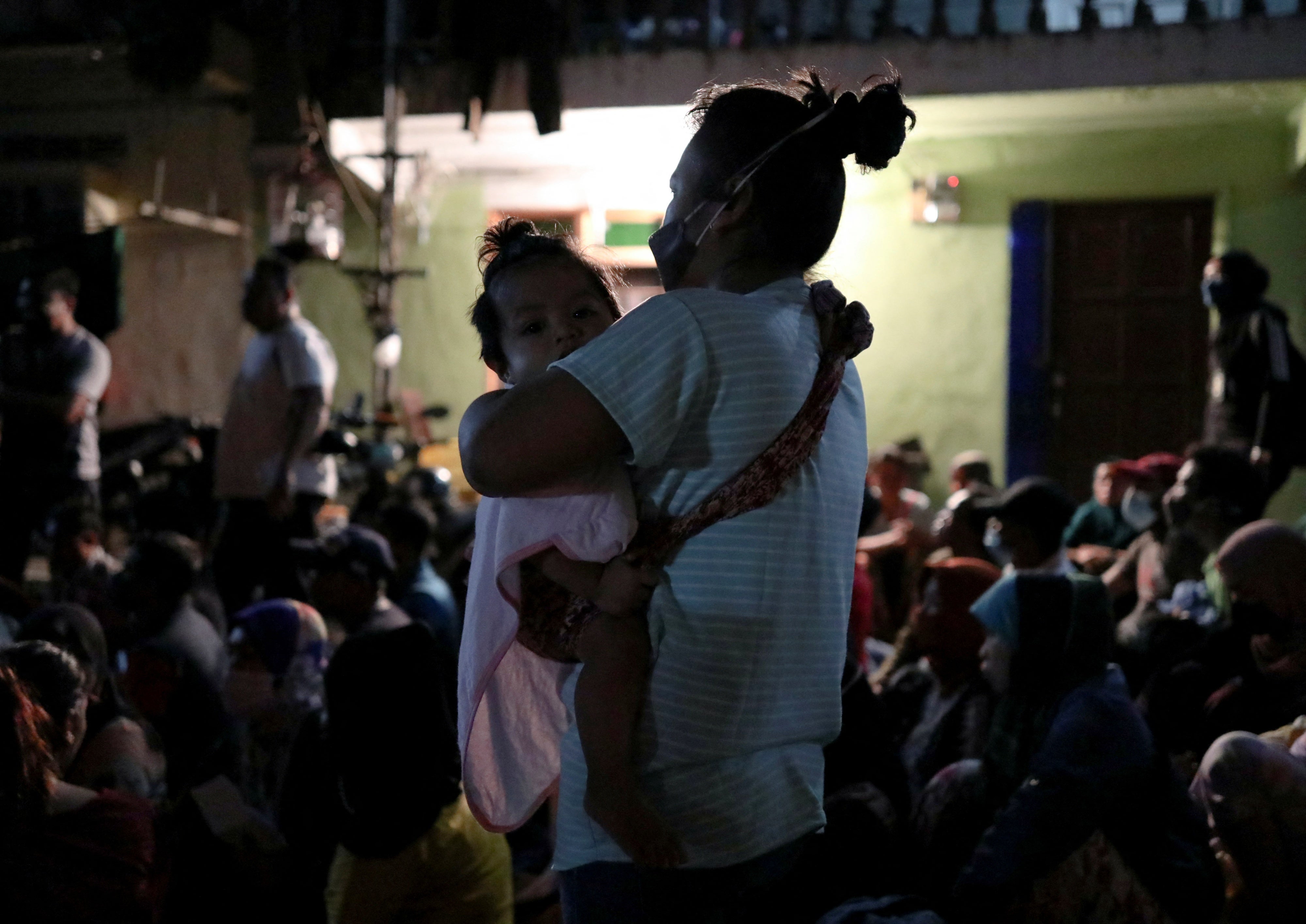 An undocumented migrant holds her daughter while being detained during an immigration raid