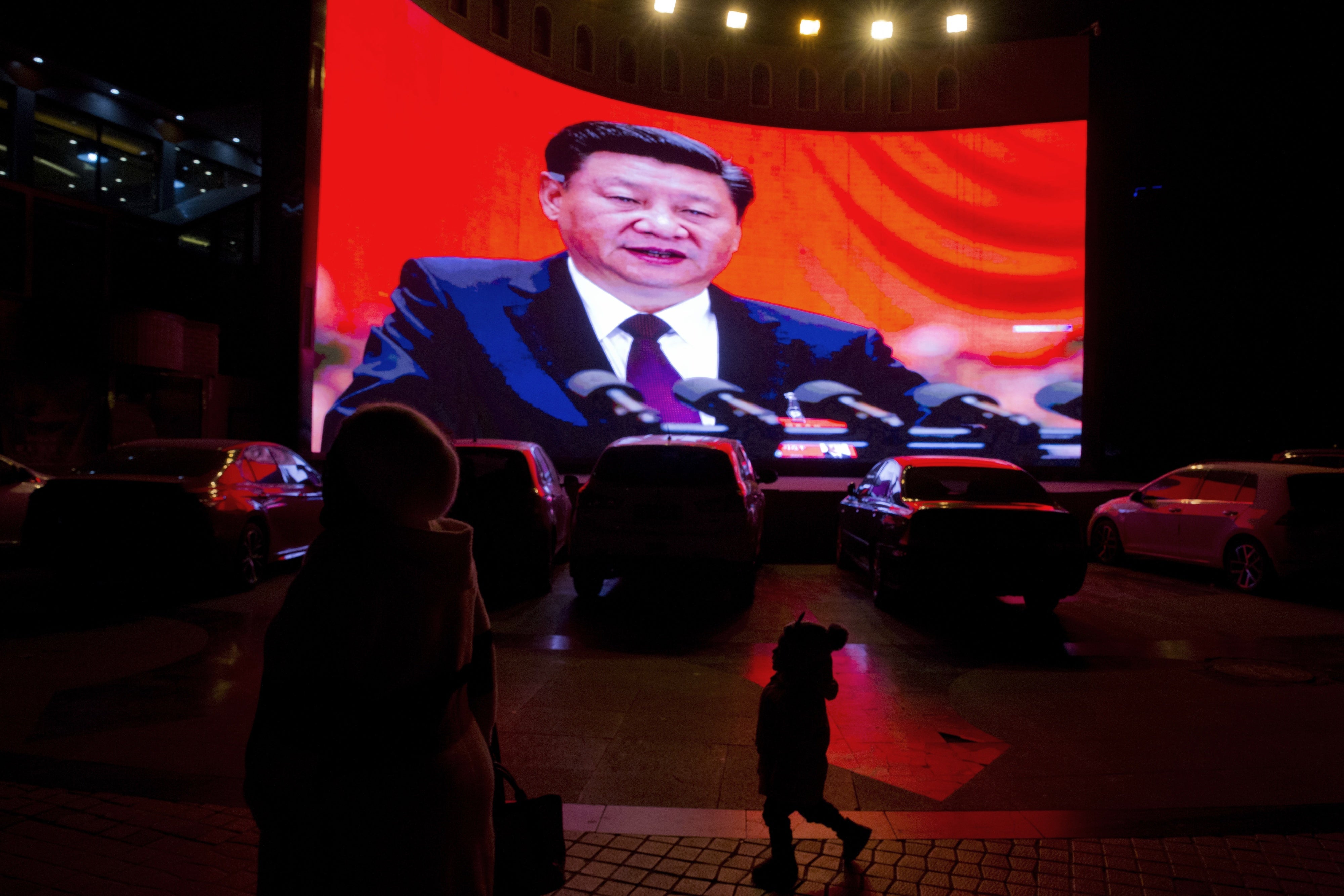 A large screen shows Chinese President Xi Jinping near a carpark in Kashgar, in western China's Xinjiang region