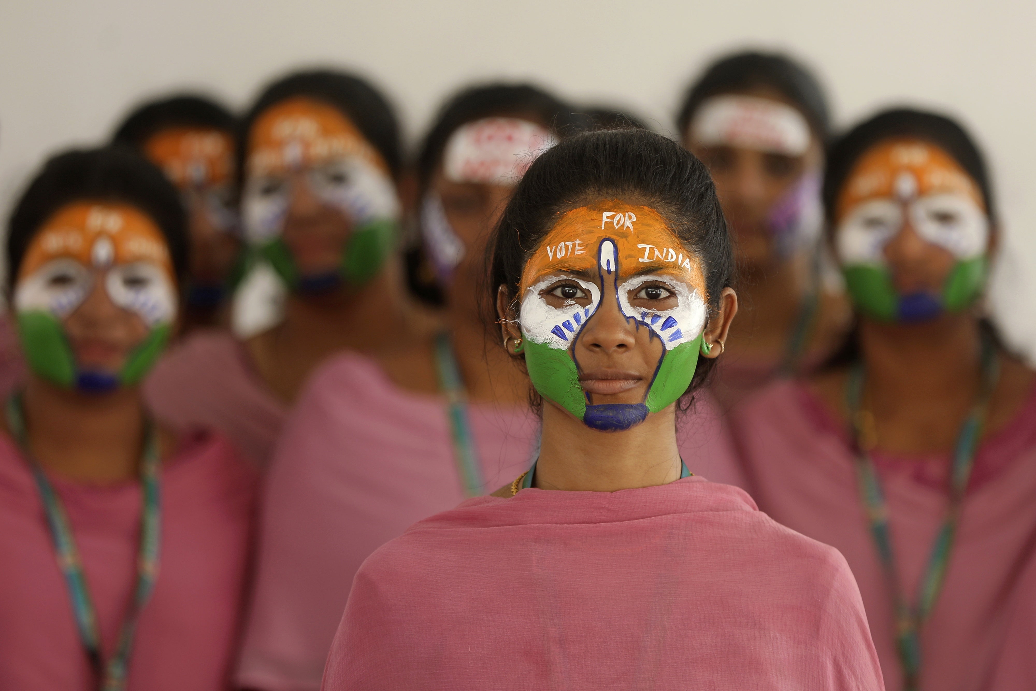 School teachers with the colors of the Indian national flag painted on their faces participate in an event to raise awareness among people to vote in the upcoming general elections