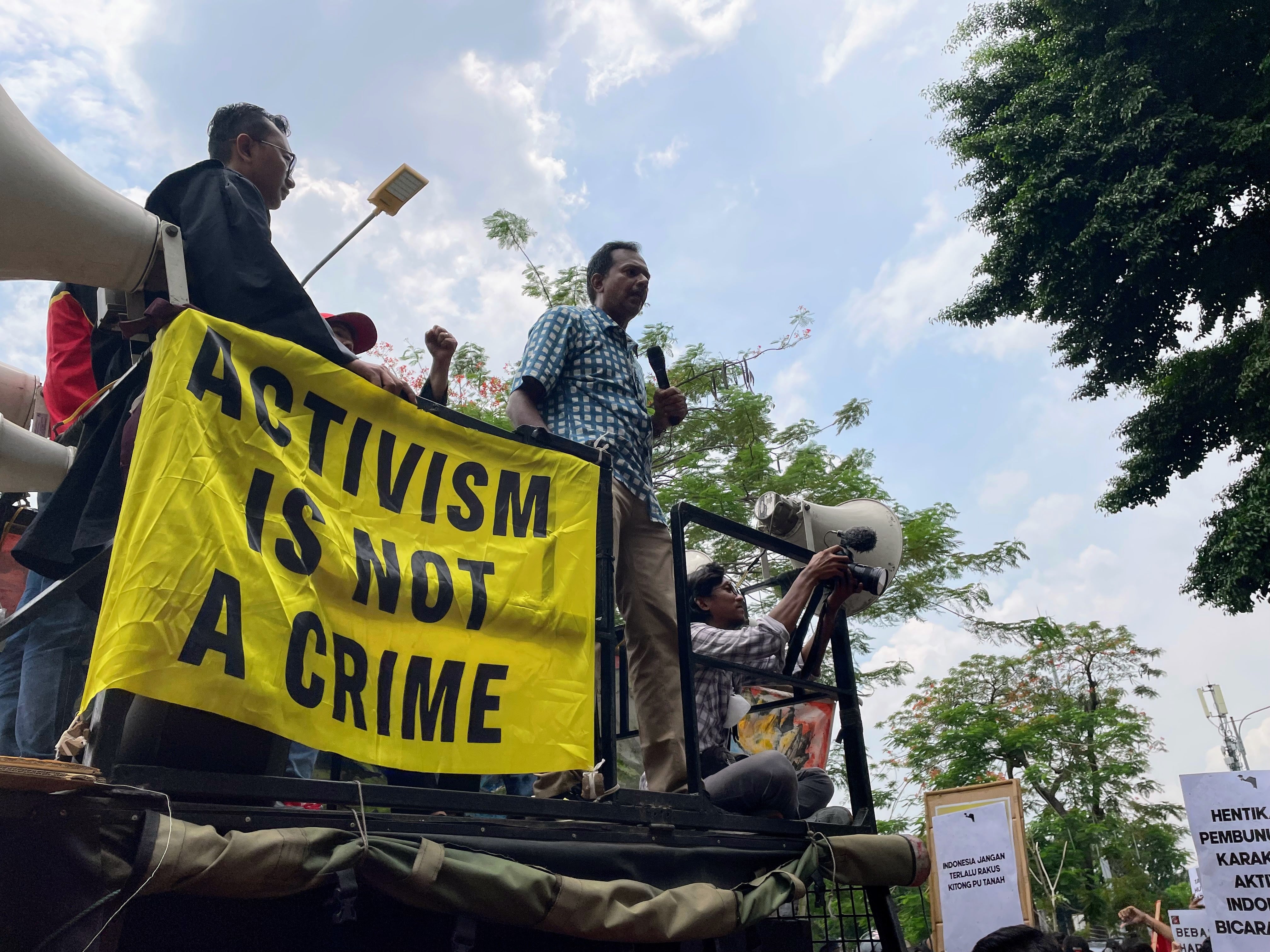 Haris Azhar berorasi dari atas sebuah truk di luar gedung Pengadilan Negeri Jakarta Timur.