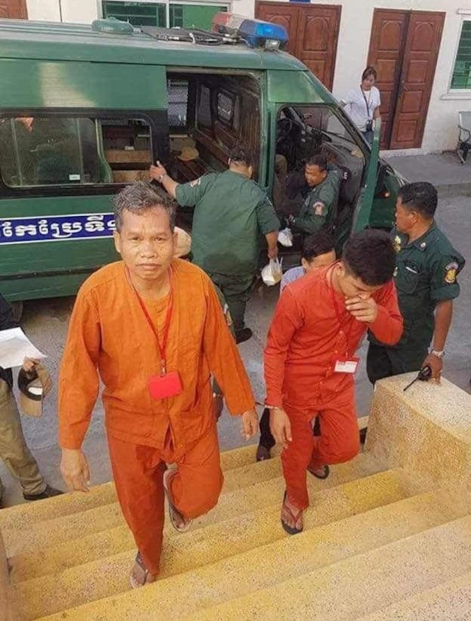 Rath Rott Mony, a Cambodian journalist, walks out of a police van in Cambodia after being forcibly returned by Thai authorities in December 2018.