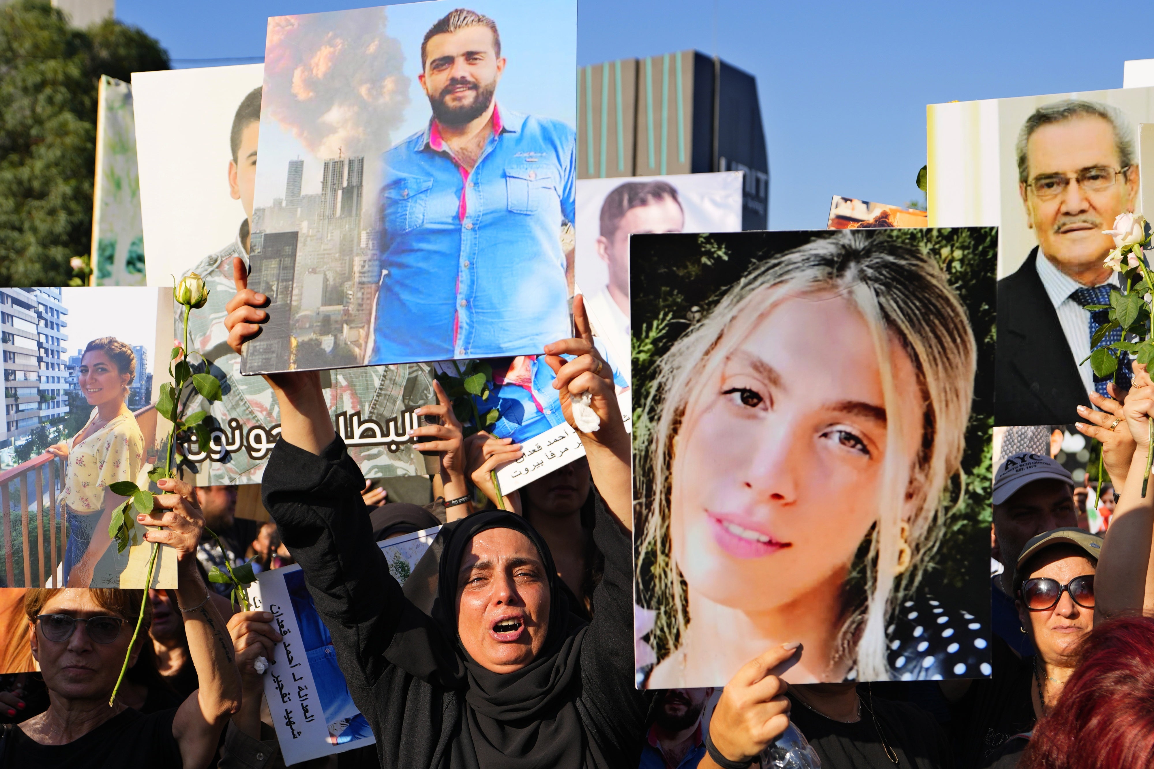 Relatives of victims of the deadly 2020 Beirut port explosion hold portraits of loved ones to mark the third anniversary of the blast, outside the port of Beirut, Lebanon, August 4, 2023. 