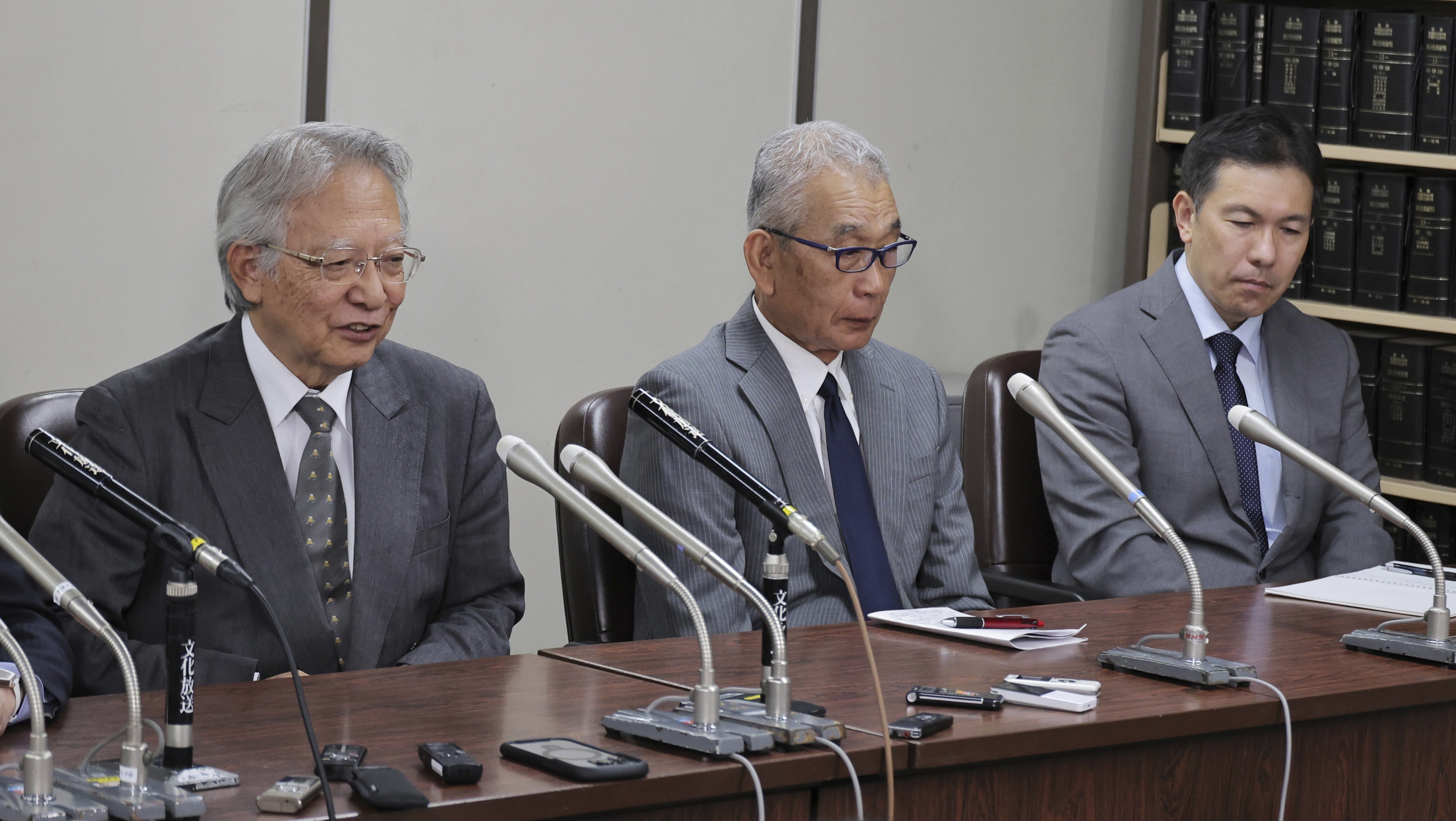 Three men attend a press conference