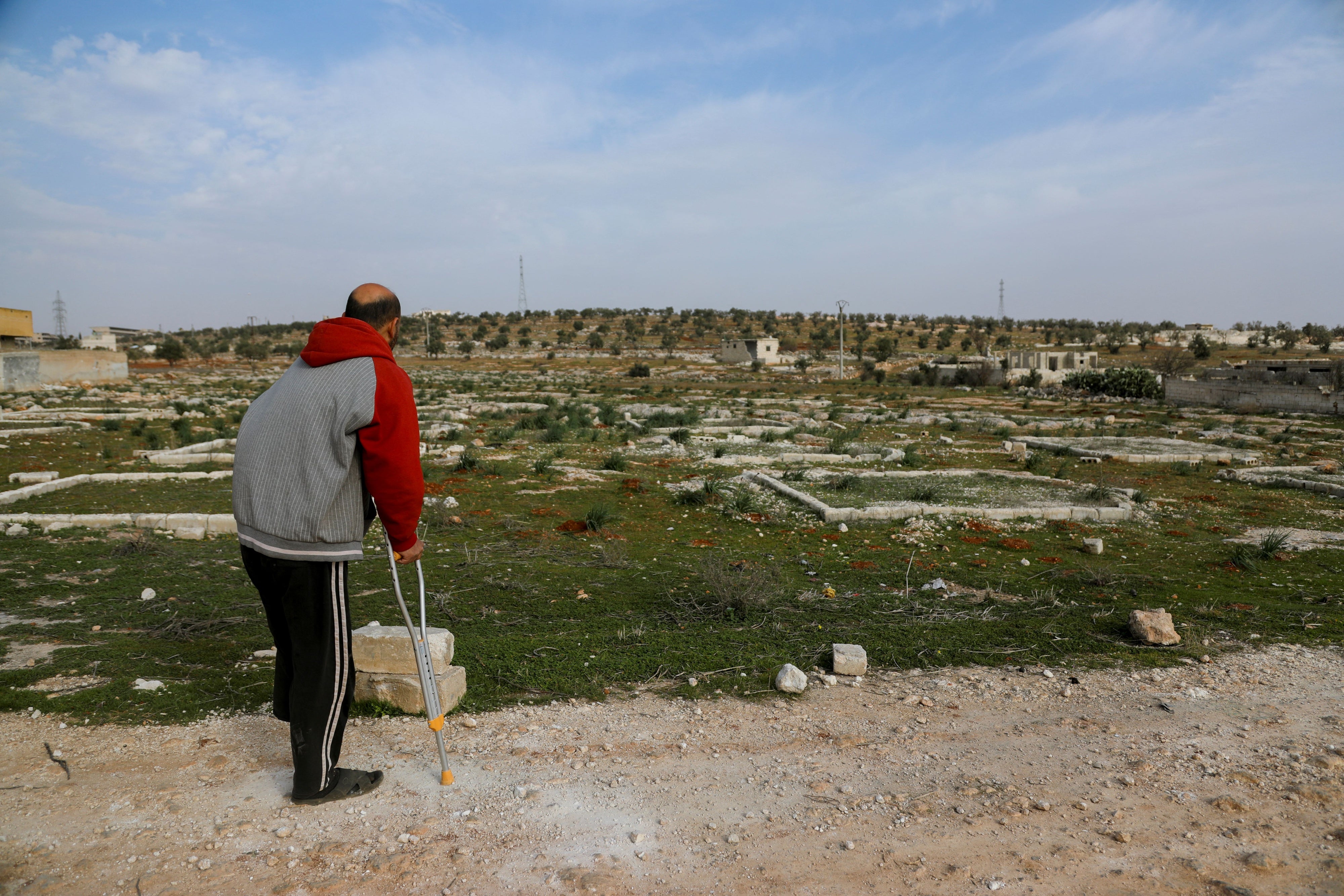 Nidal Ahmad stands near his olive farm in Aleppo, Syria on March 4, 2025. Its location near a former Syrian Army military camp has prevented him from harvesting crops for years. Last December, Nidal returned to check on his land and lost his foot in a landmine explosion. 