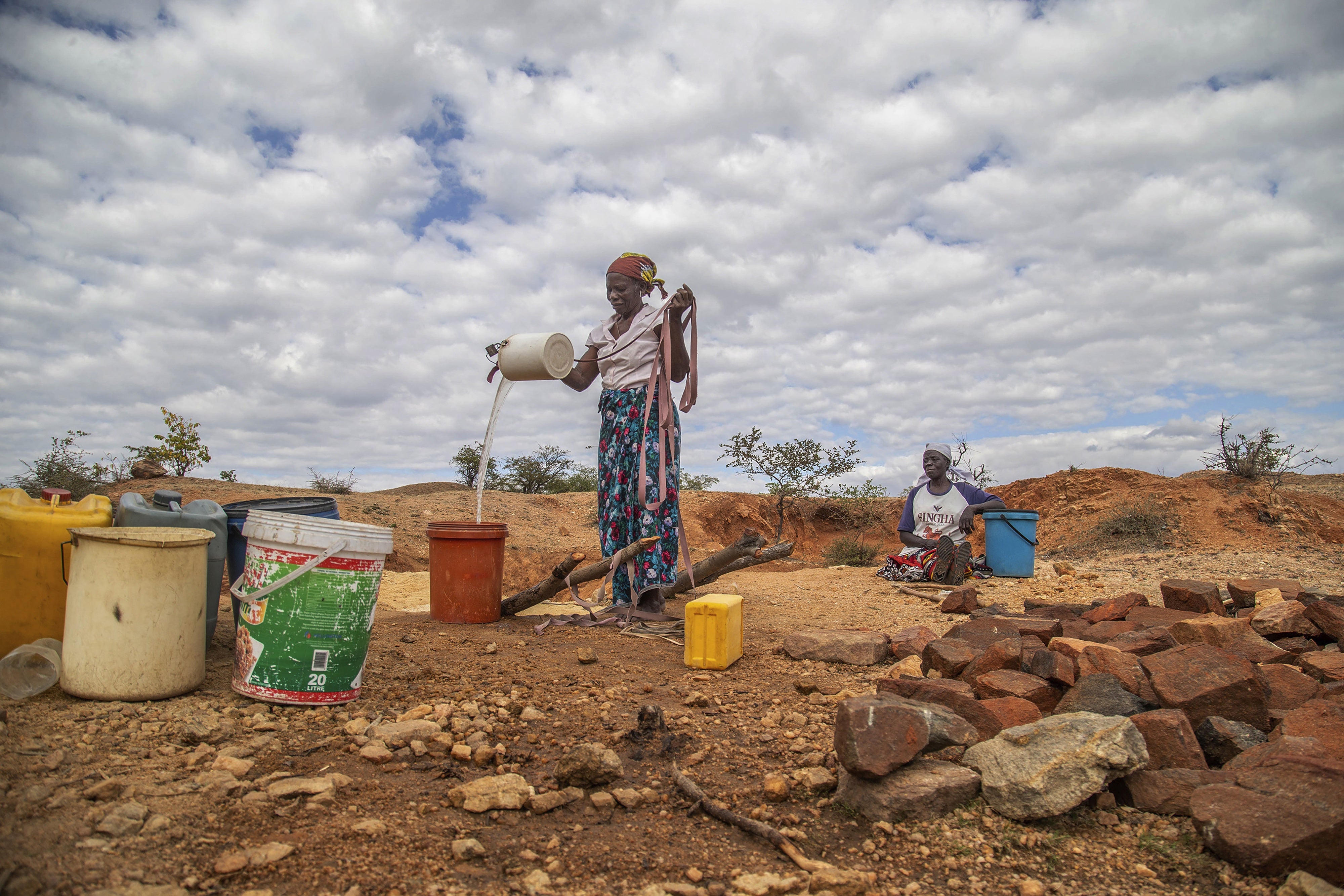 Villagers fetch water from a makeshift borehole during a drought in Mudzi, Zimbabwe, July 2, 2024.