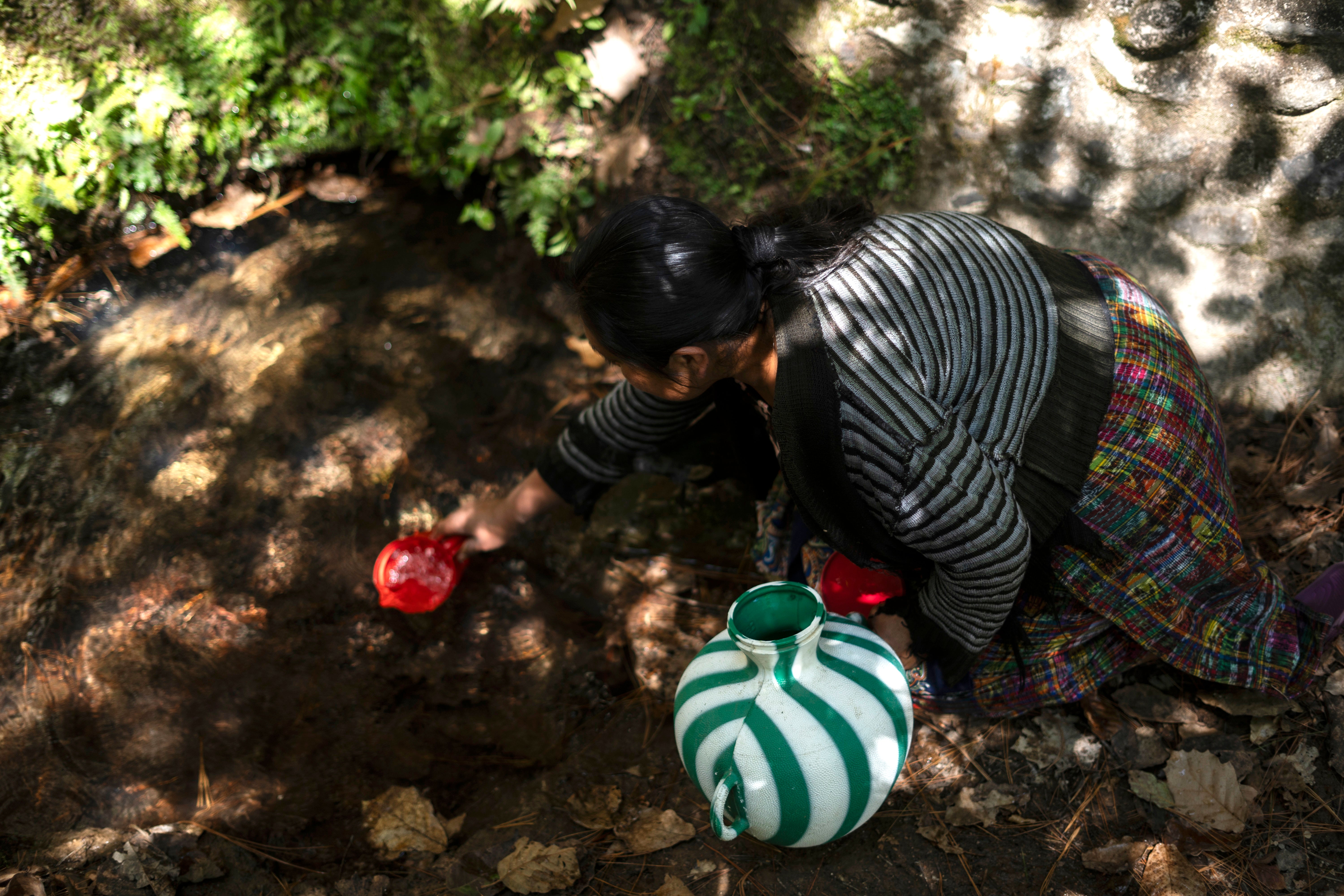 Una mujer recoge agua para beber de un pozo en el municipio de Santa María Chiquimula, departamento de Totonicapán, Guatemala, 11 de marzo de 2025.