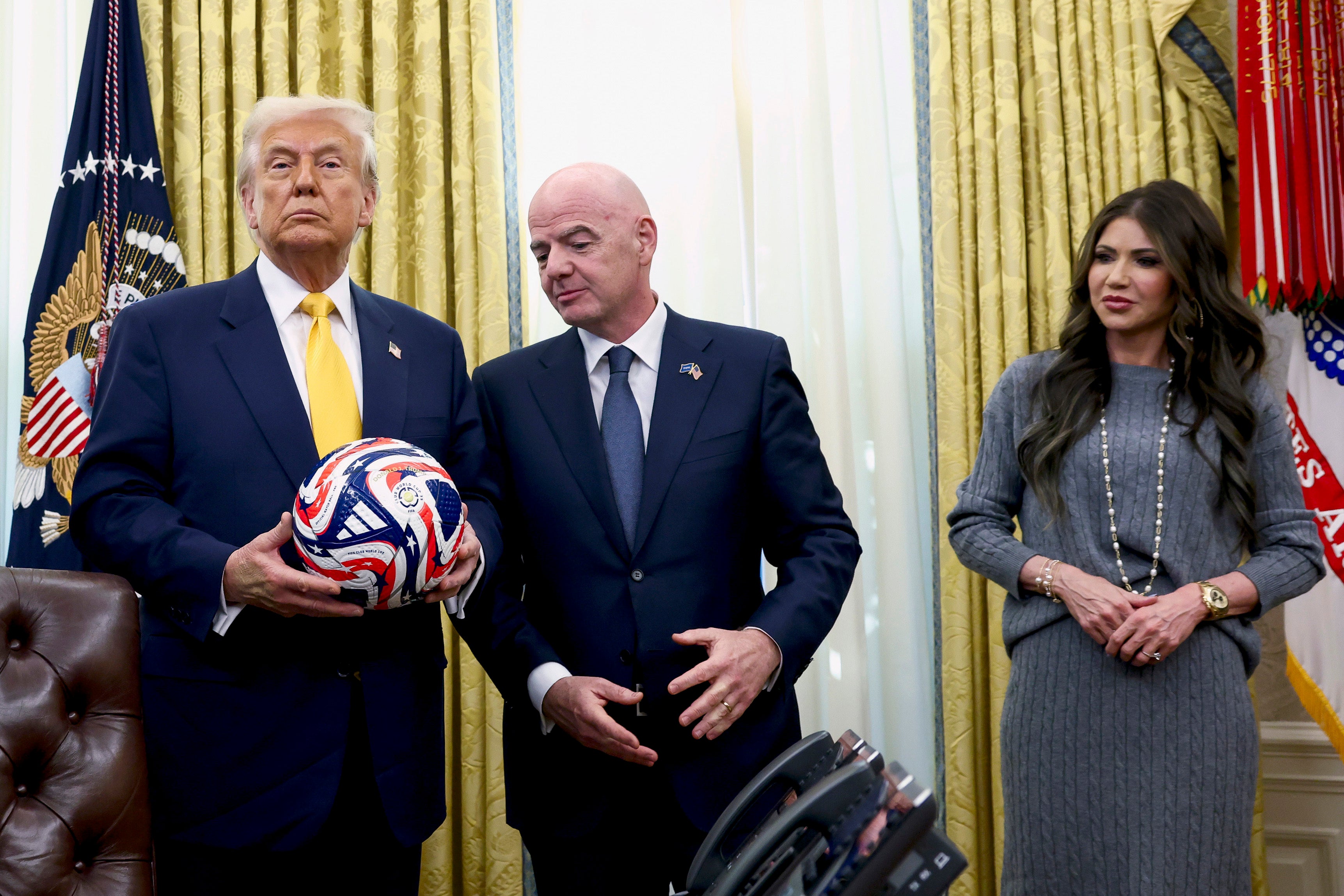 US President Donald Trump (L), with FIFA President Gianni Infantino (C) and Homeland Security Secretary Kristi Noem watch in the Oval Office of the White House in Washington, DC, March 7, 2025.