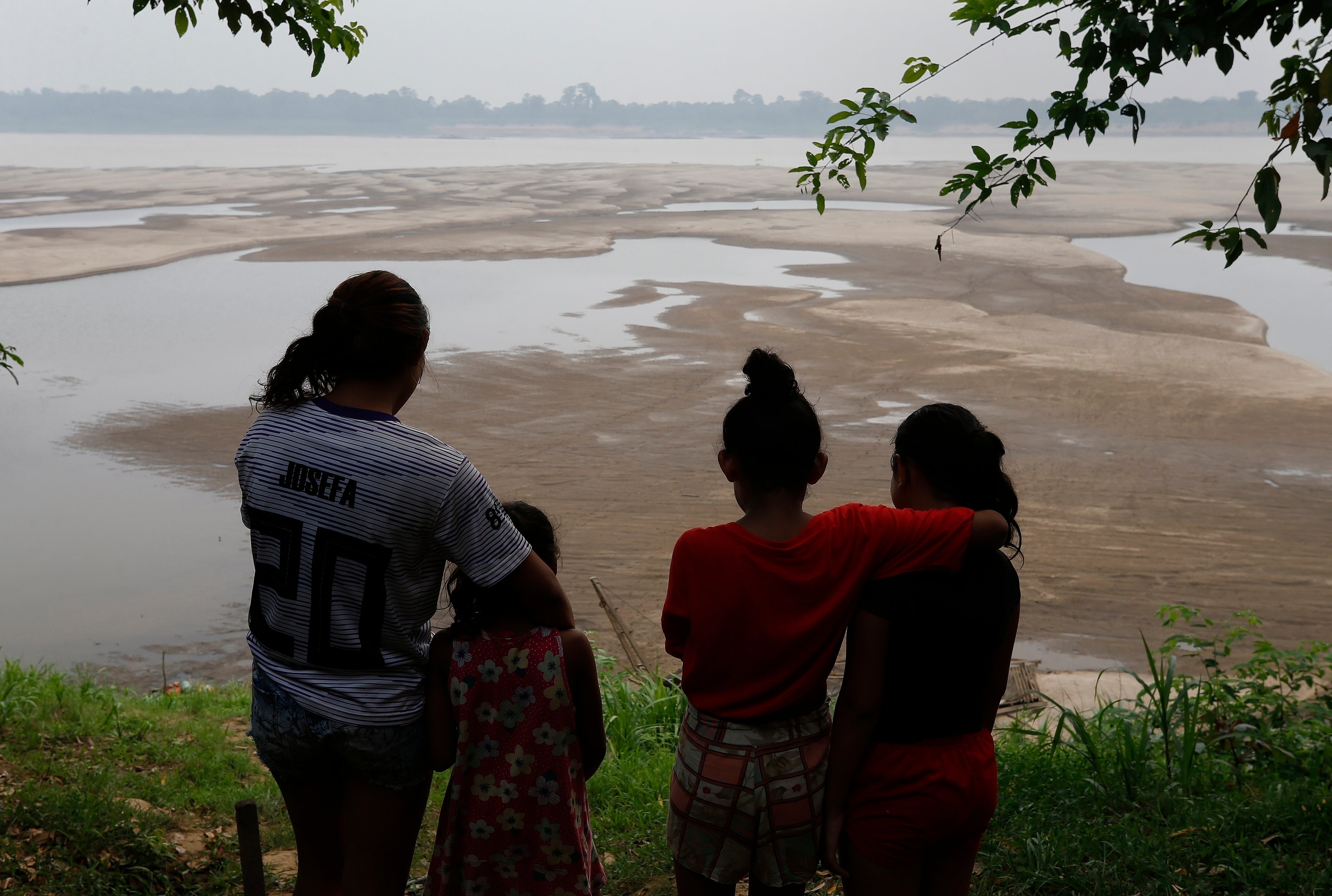 Residents look out at the Madeira River, a tributary of the Amazon River, amid a drought in Humaita, Brazil, September 7, 2024.