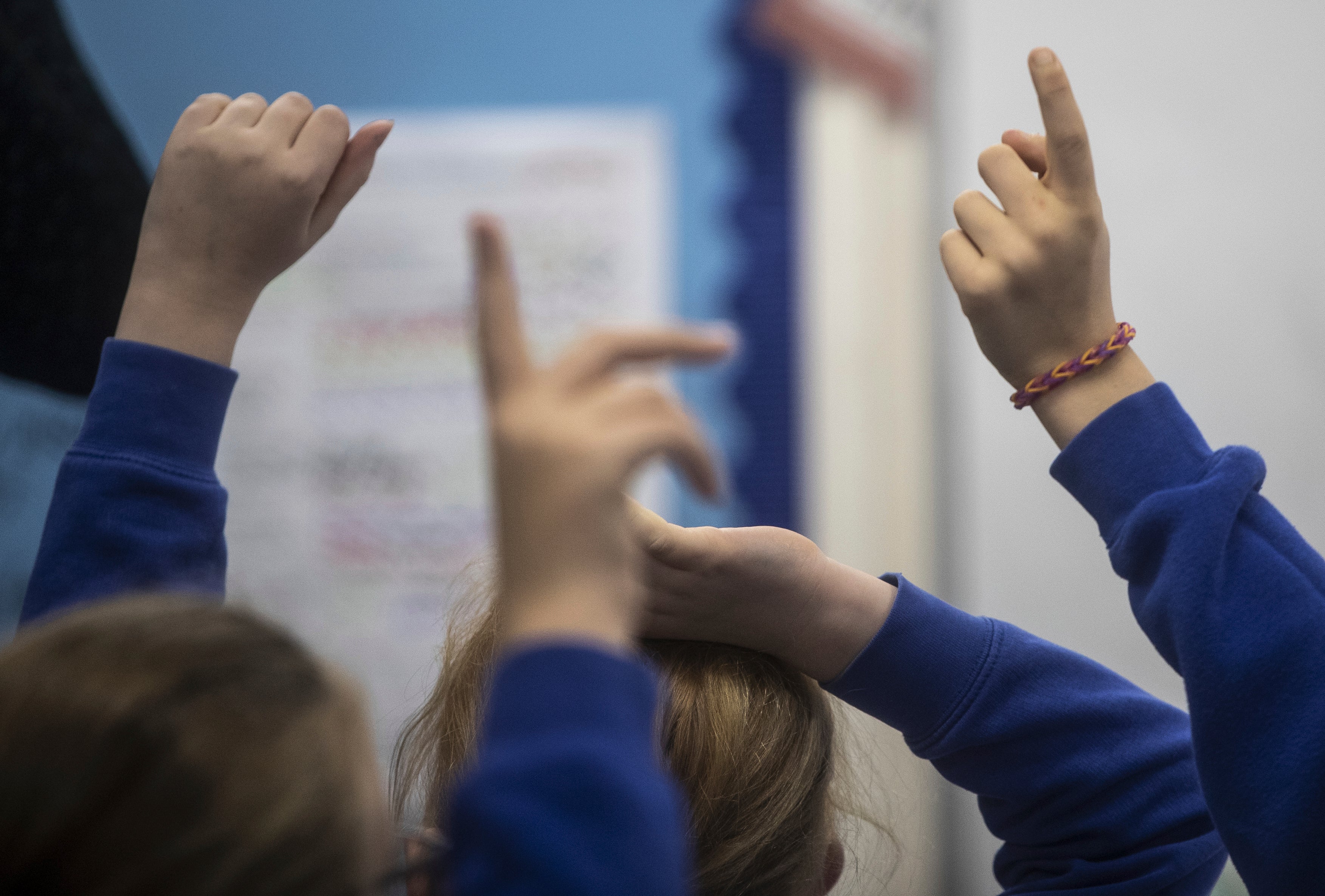 Raised hands in a classroom