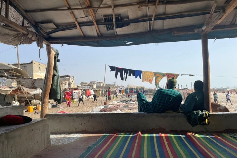 Two fisherman relax in a shelter on the beach on the Langue de Barbarie, April 2025. 
