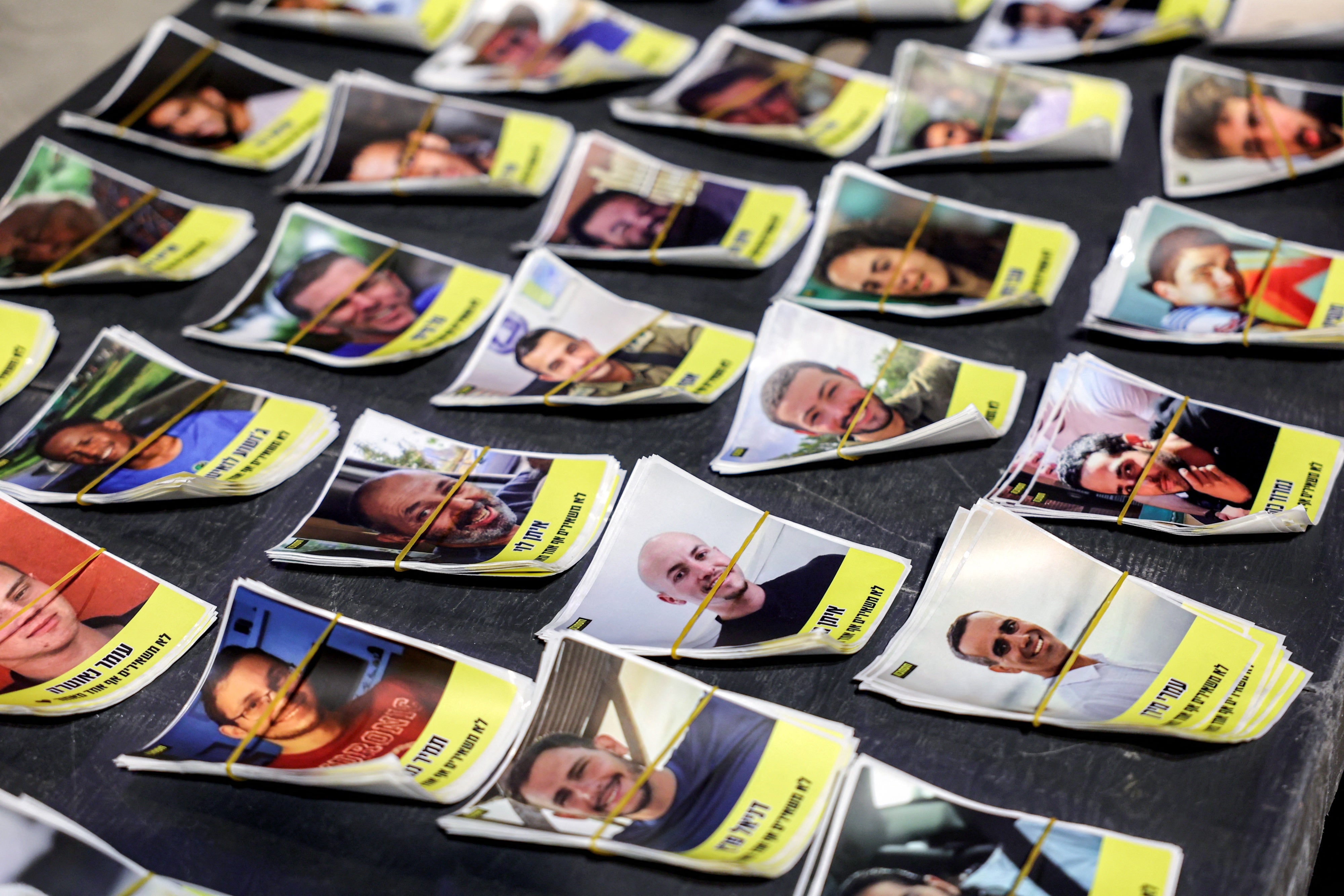 Des photos d'otages israéliens détenus à Gaza étaient exposées sur le sol lors d'une manifestation organisée par leurs familles à Tel Aviv, le 27 septembre 2025. 