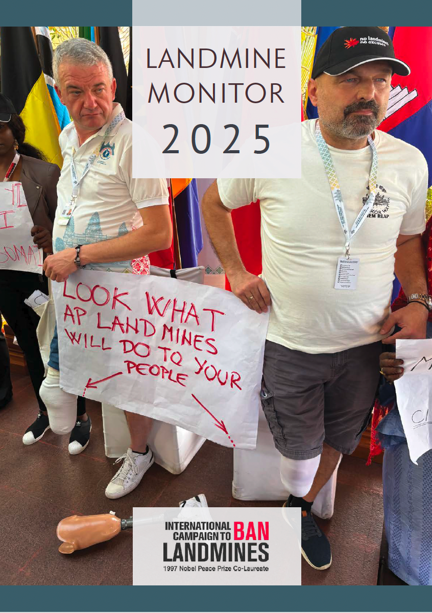 Landmines survivors hold a sign on landmine use in protest. 