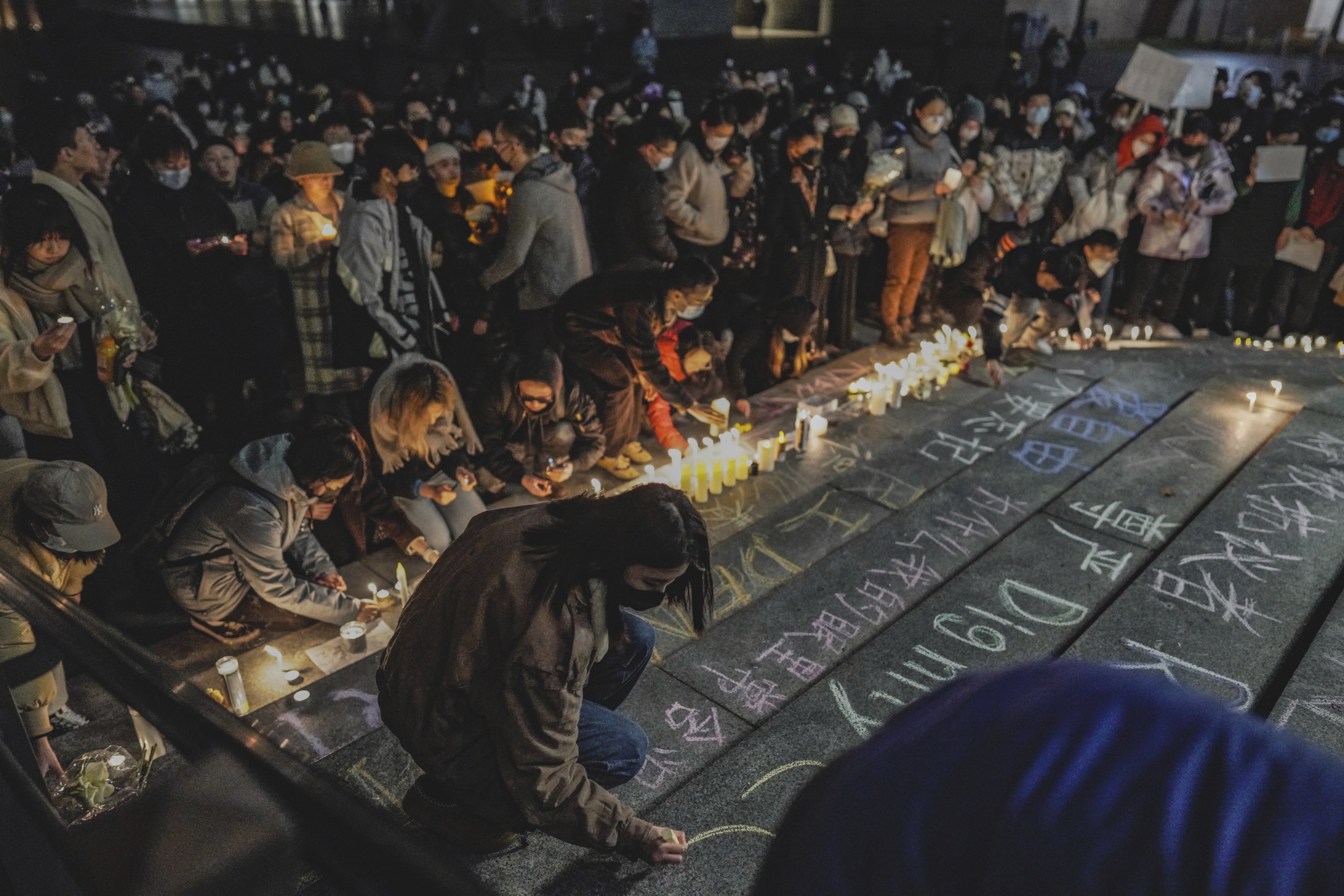 A protester writes "dignity" in English and Chinese in a show of solidarity with the White Paper protest in China at the University of Washington in Seattle, December 4, 2022.