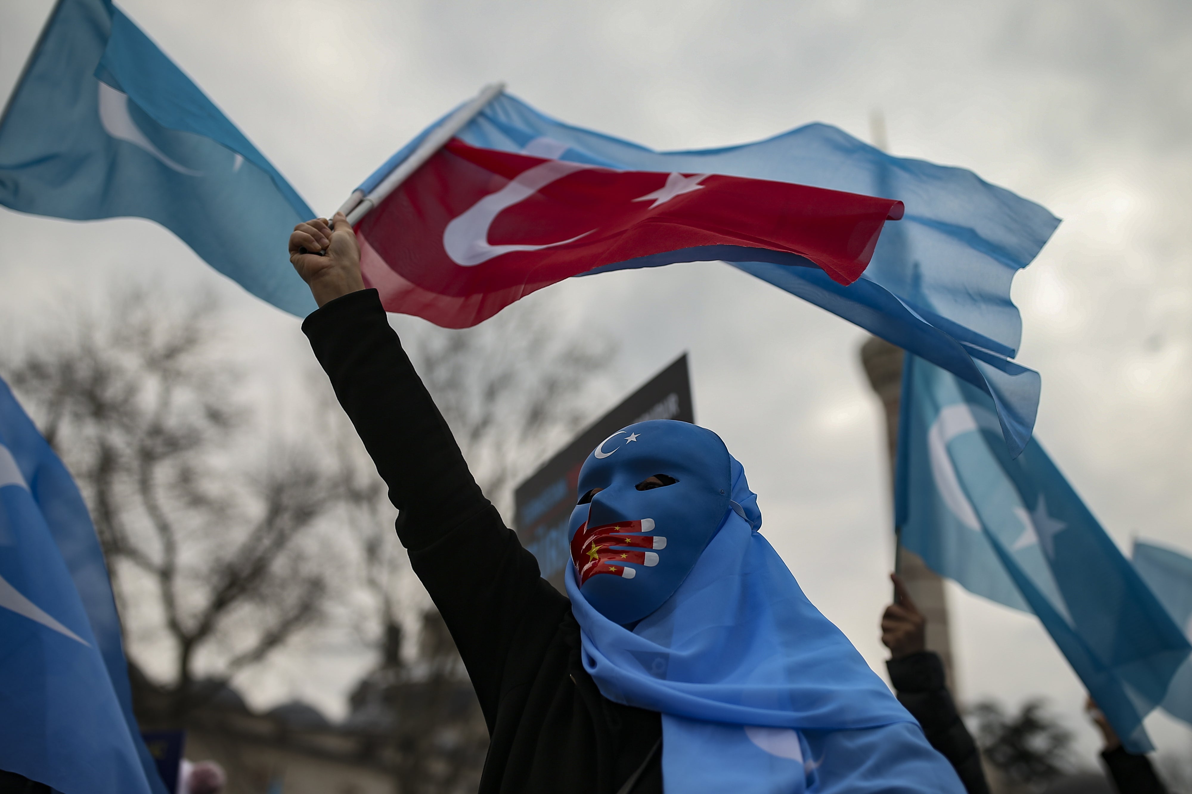 A person from the Uyghur community living in Türkiye protests against the visit of China's Foreign Minister Wang Yi to Türkiye, in Istanbul, March 25, 2021. 