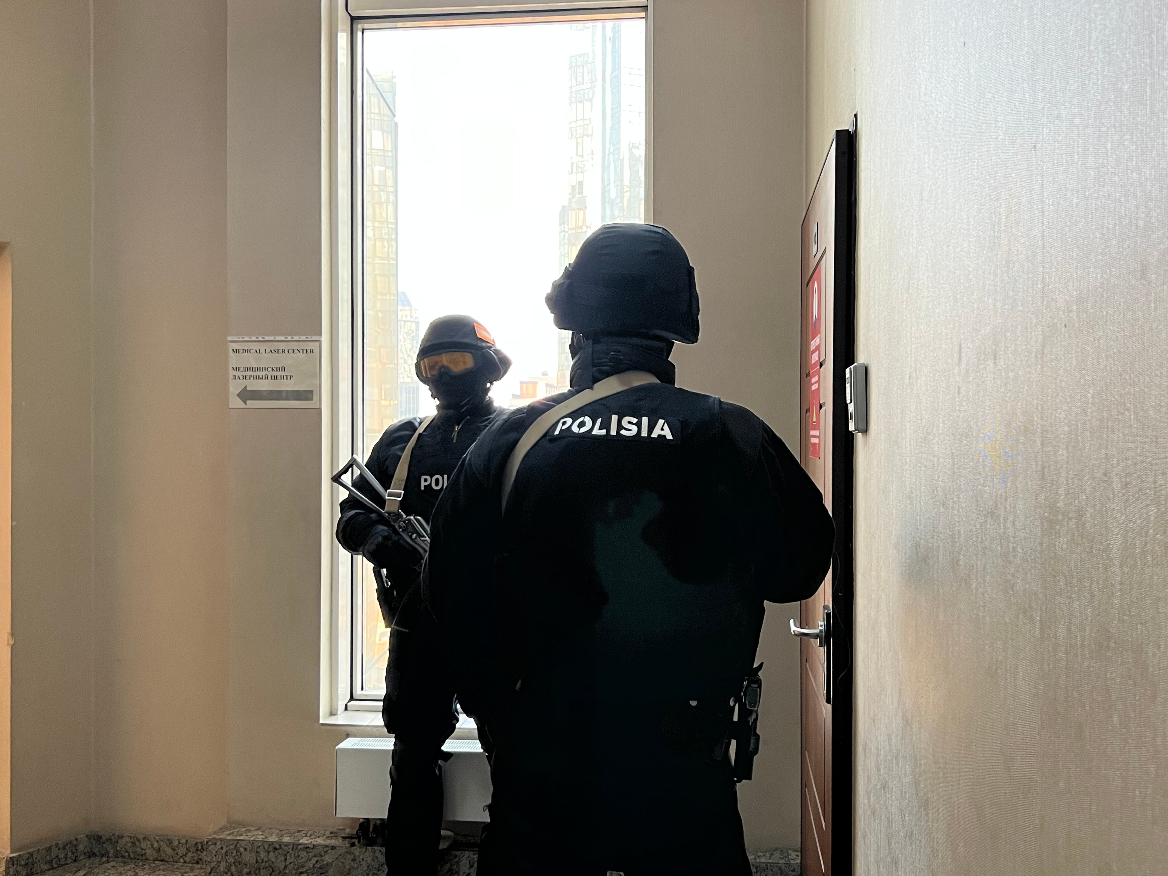 Special police force officers stand outside the Orda.kz editorial office in Almaty, Kazakhstan, during a December 1, 2025 search of the premises after authorities opened a criminal case against Gulnara Bazhkenova, the publication's editor-in-chief, for allegedly “disseminating knowingly false information."