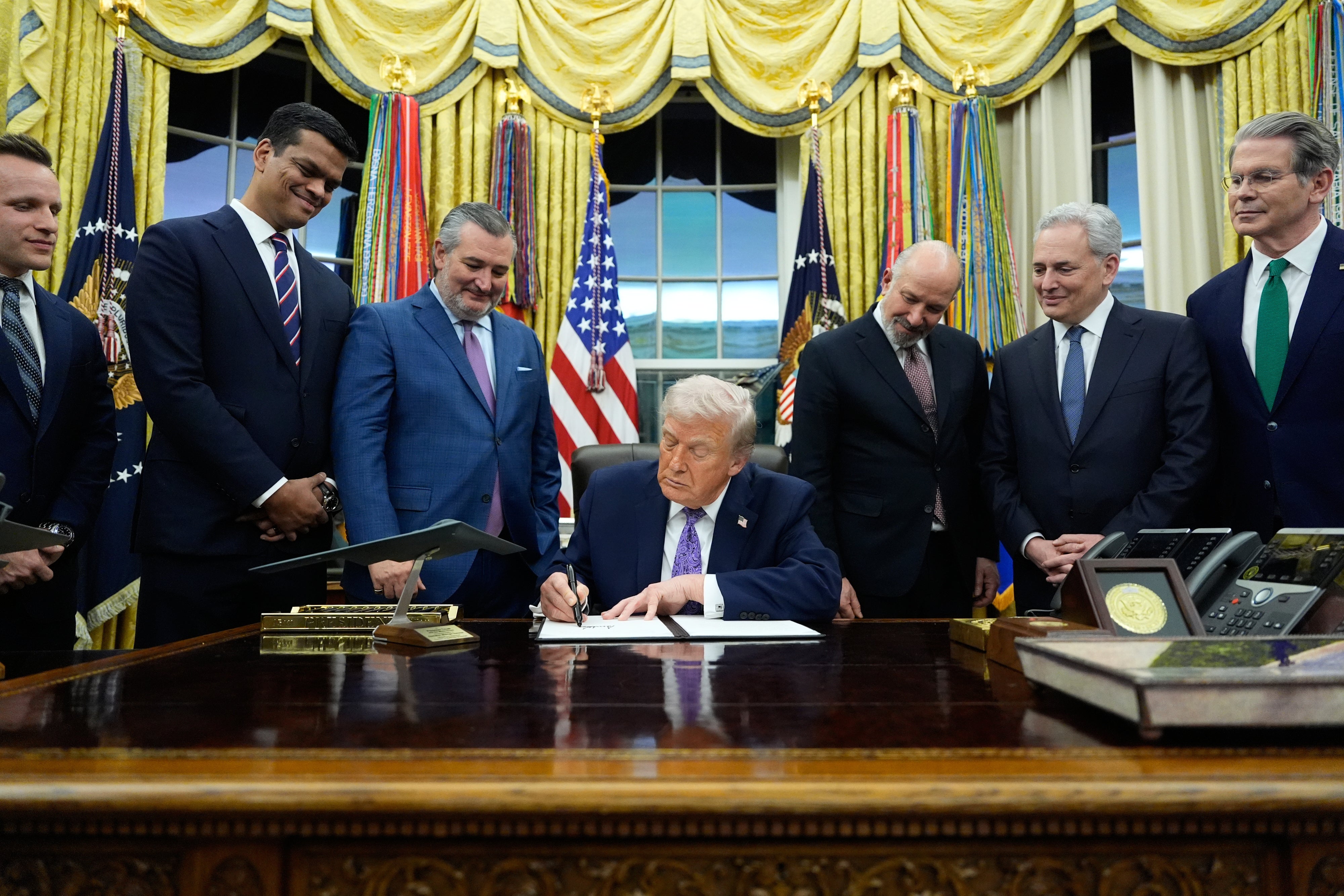 US President Donald Trump signs an Al initiative in the Oval Office of the White House, Washington DC, December 11, 2025.