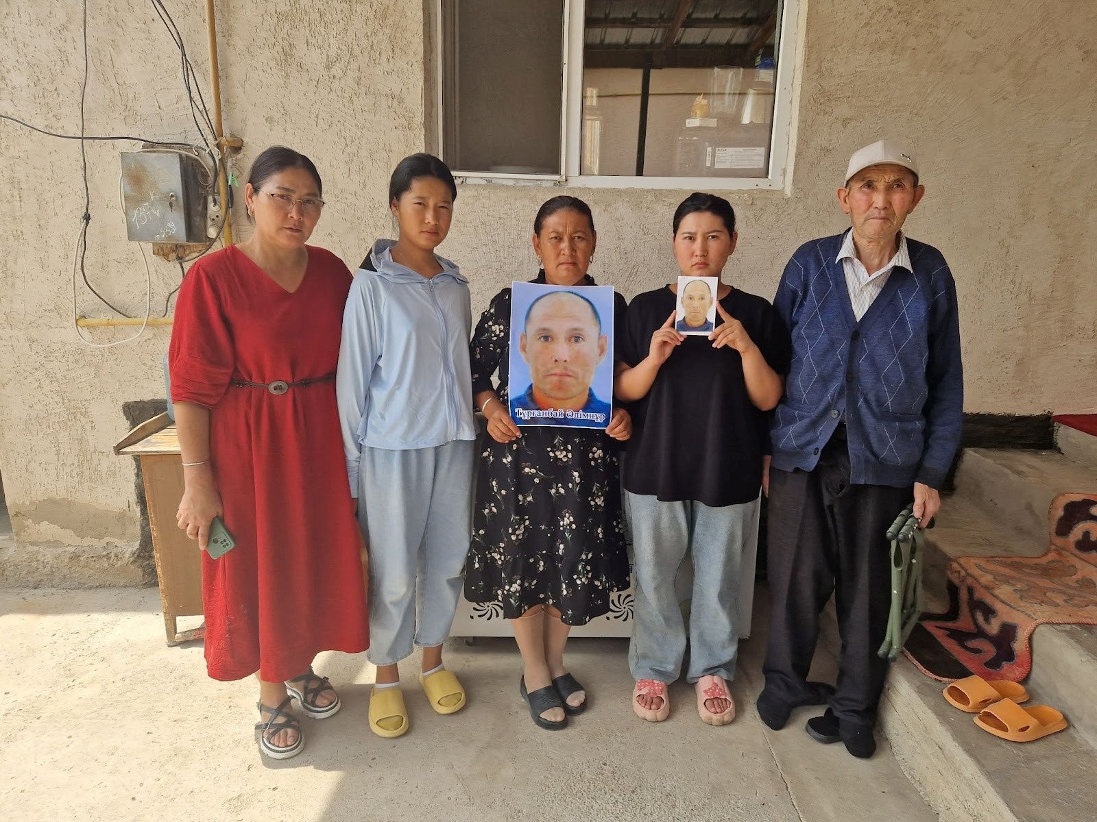Family members and neighbor (far right) of Alimnur Turganbay, a Kazakhstan citizen detained in China, outside their house in Uzynagash village, located outside Almaty, Kazakhstan on August 4, 2025.