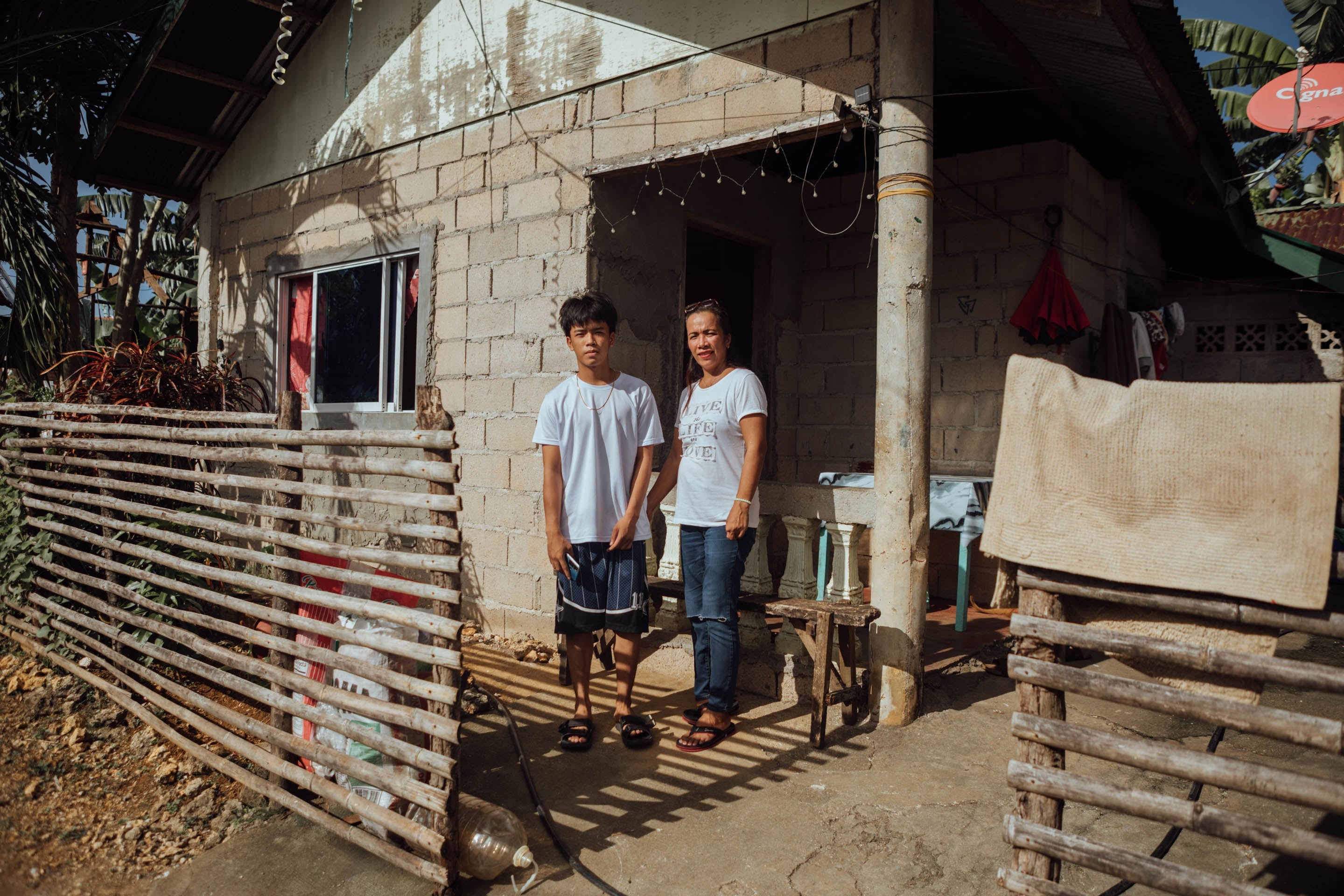 Mirasol with her son outside their home in the No Build Zone in Del Carmen, Siargao, Philippines, 2025. 