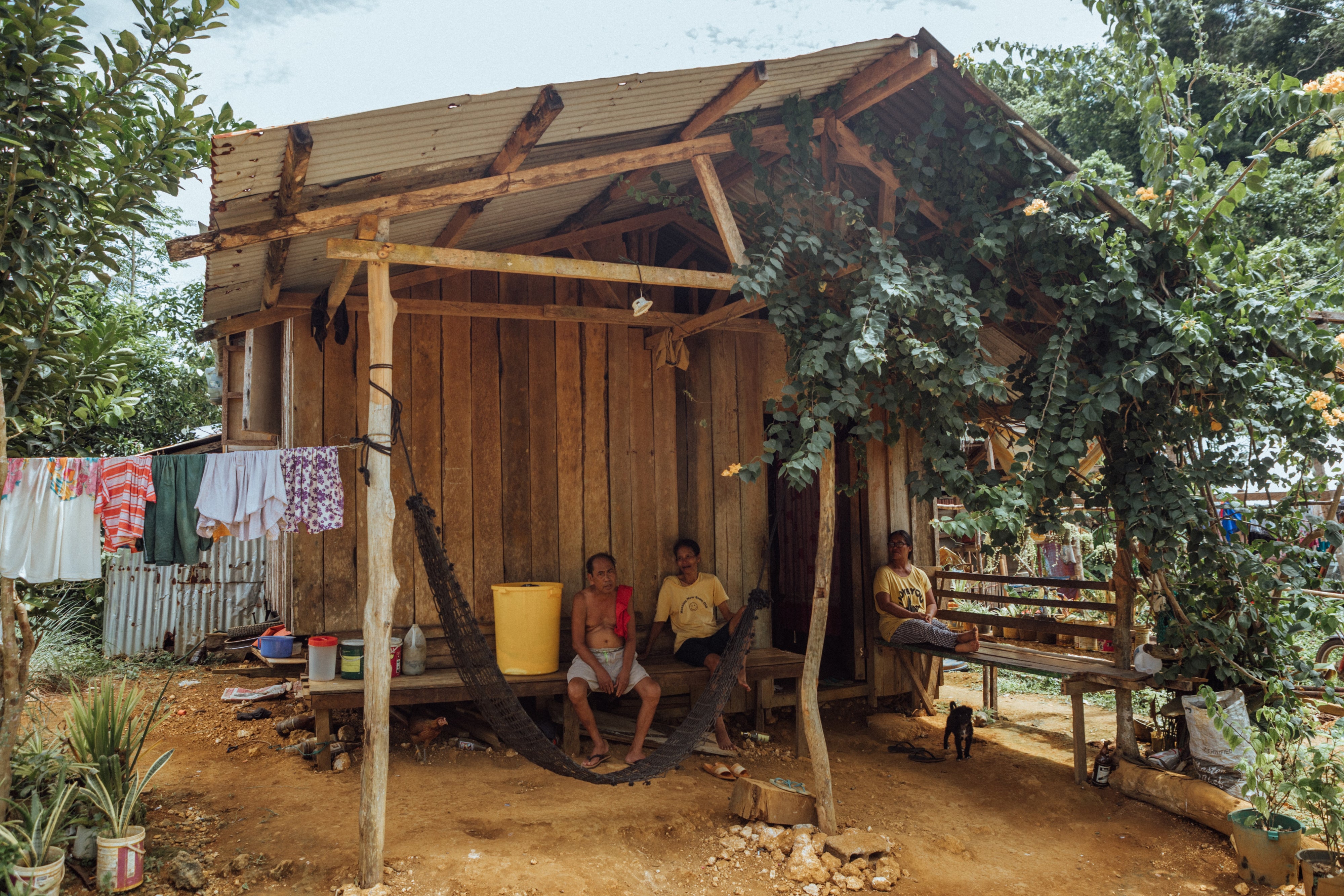 Zenaida (R) with her husband (L) outside their home in Siargao, Philippines, 2025.