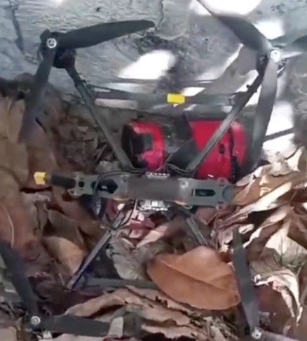 Screenshot from a video uploaded to the social media platform X on November 28, 2025, showing a quadcopter drone on the ground and an apparent unexploded 3D-printed munition.