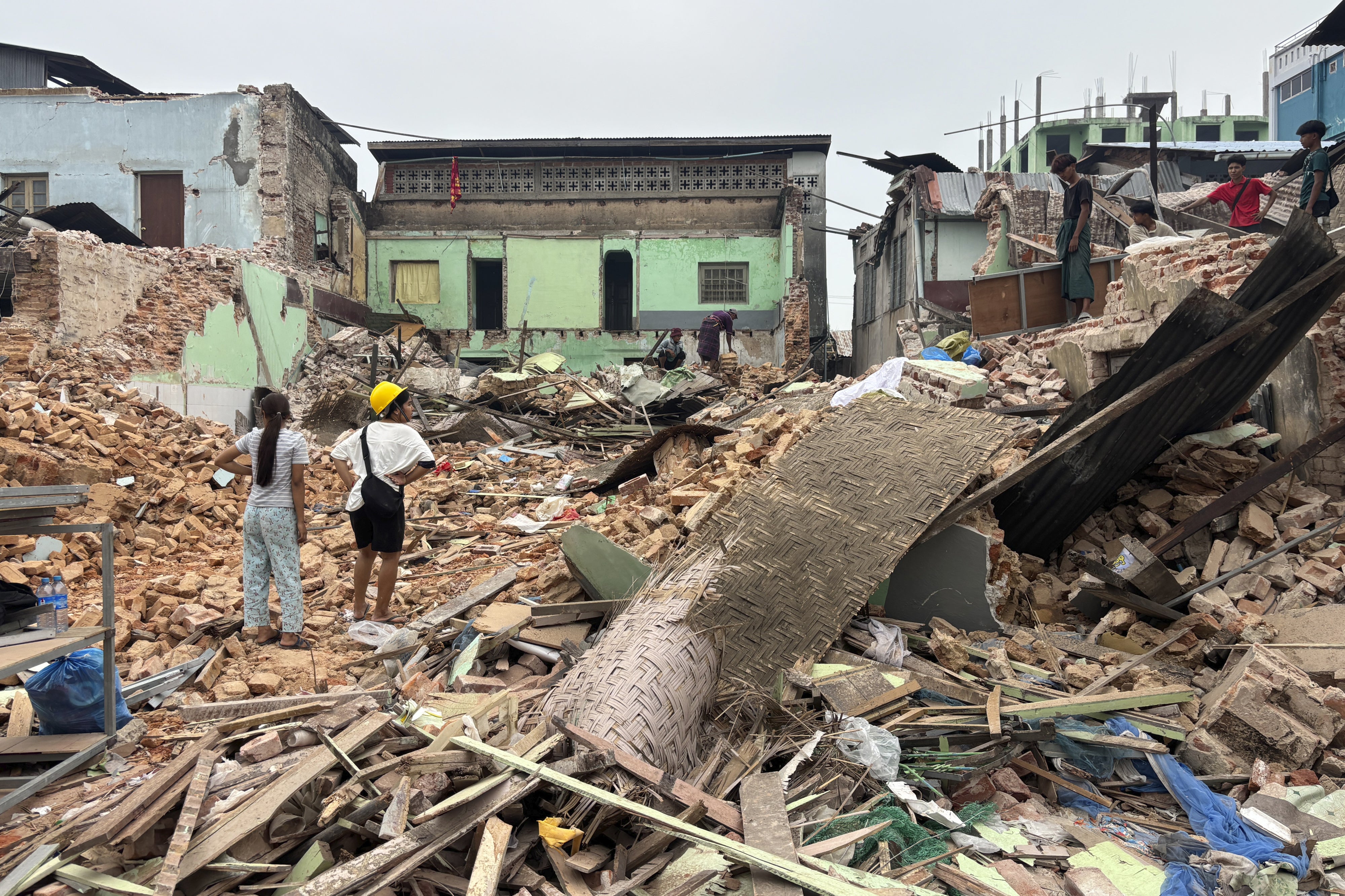 Following the March 28, 2025 earthquake in Myanmar, people clear debris from damaged buildings in Naypyidaw, April 7, 2025.
