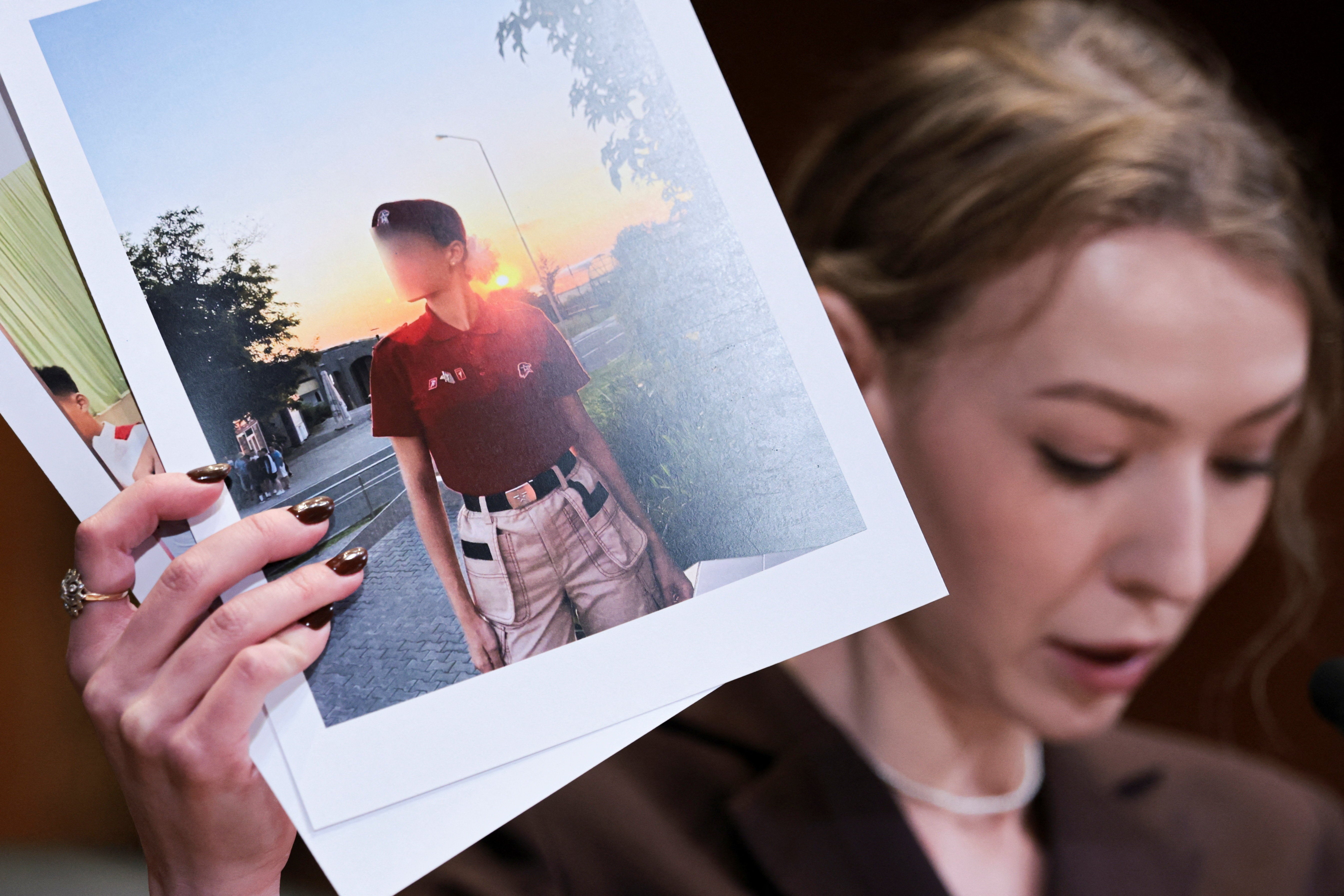 Kateryna Rashevska, a legal expert at the Regional Center for Human Rights (Kyiv, Ukraine), holds a picture she says depicts an abducted Ukrainian child, Washington DC, US, December 3, 2025.