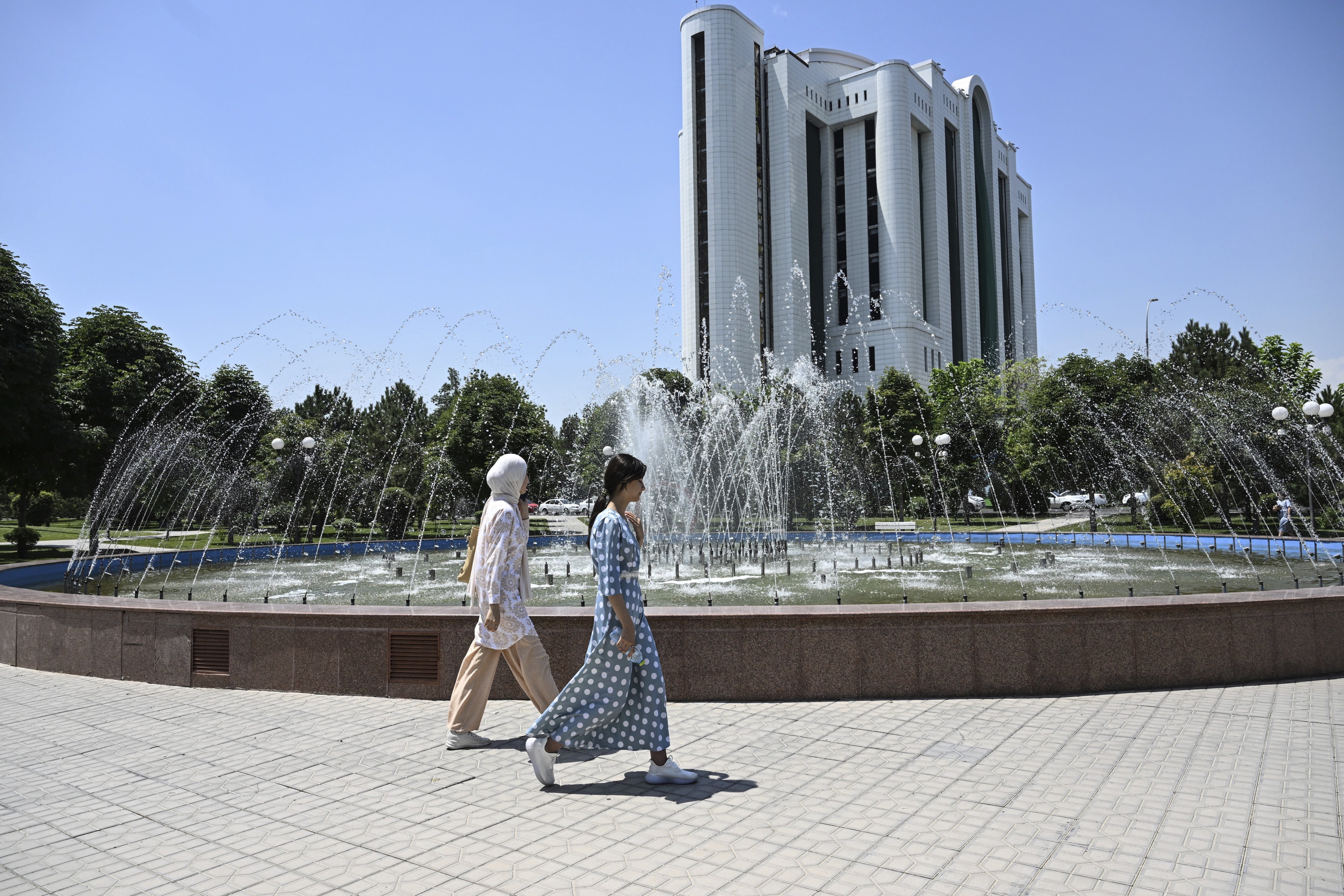 Women walk past a fountain in Tashkent, Uzbekistan, July 6, 2023.