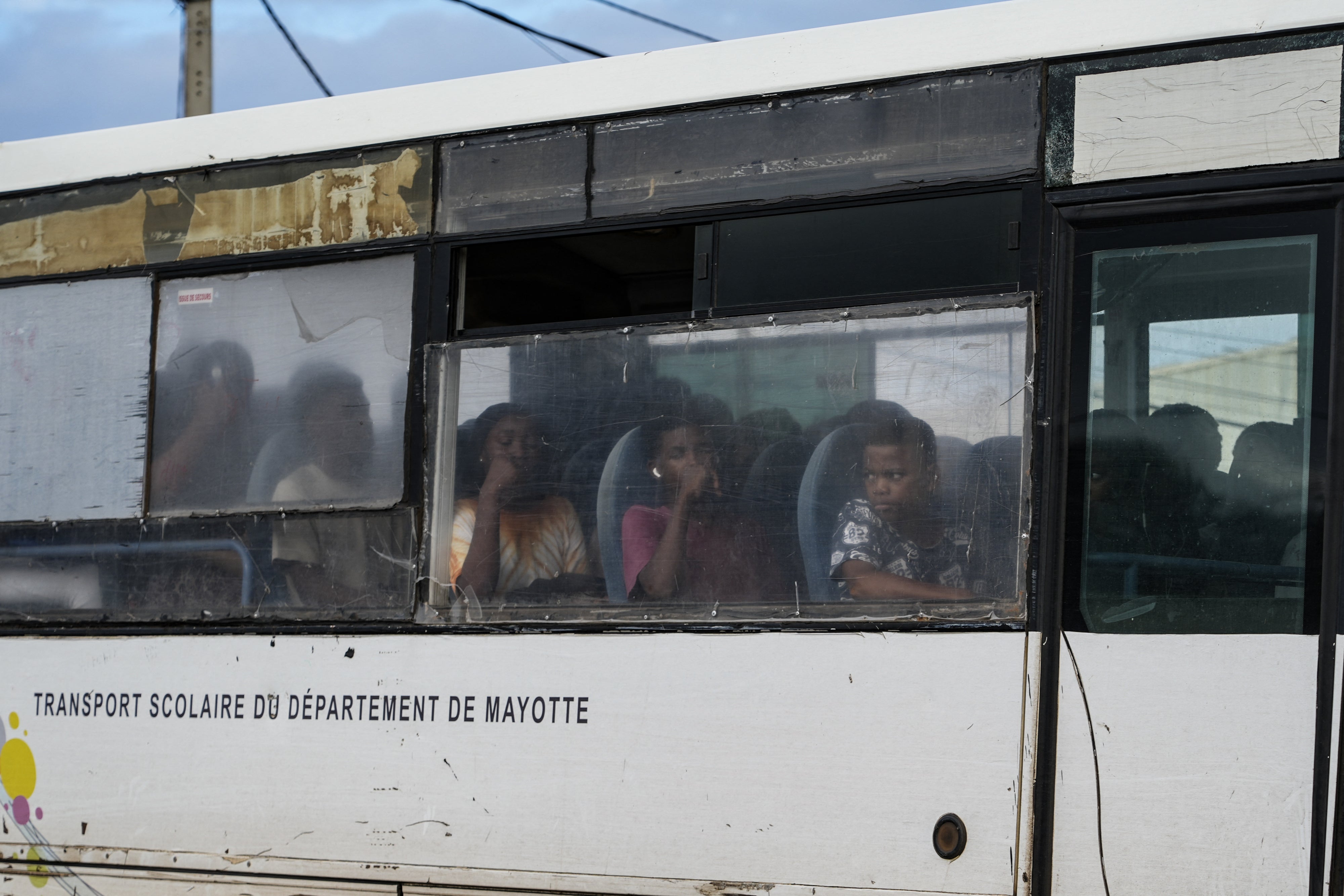 Students sit aboard a school bus, in Kaweni, in the township of Mamoudzou, in the French Indian Ocean territory of Mayotte, on October 28, 2025. 