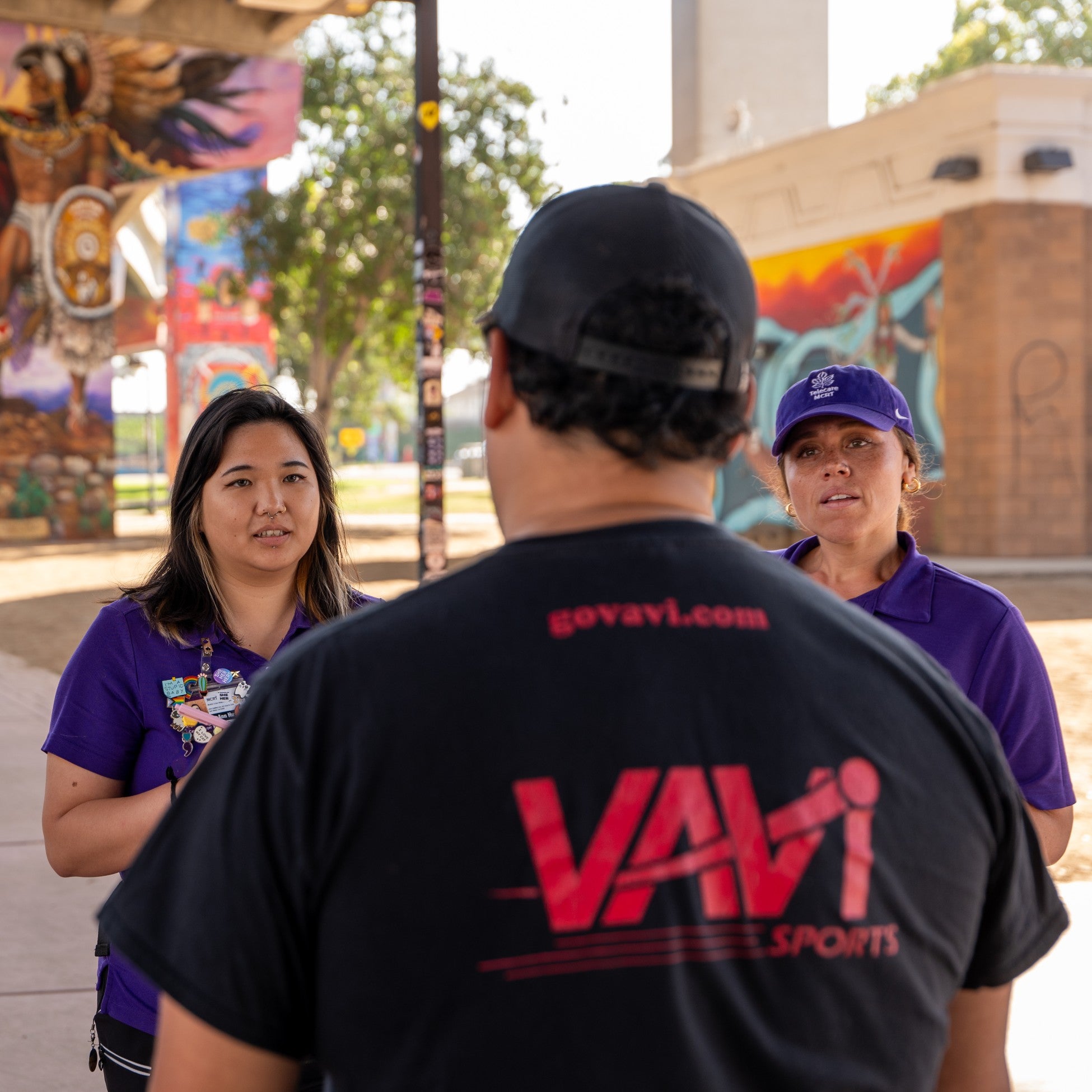 Two crisis response team members speak to a man 