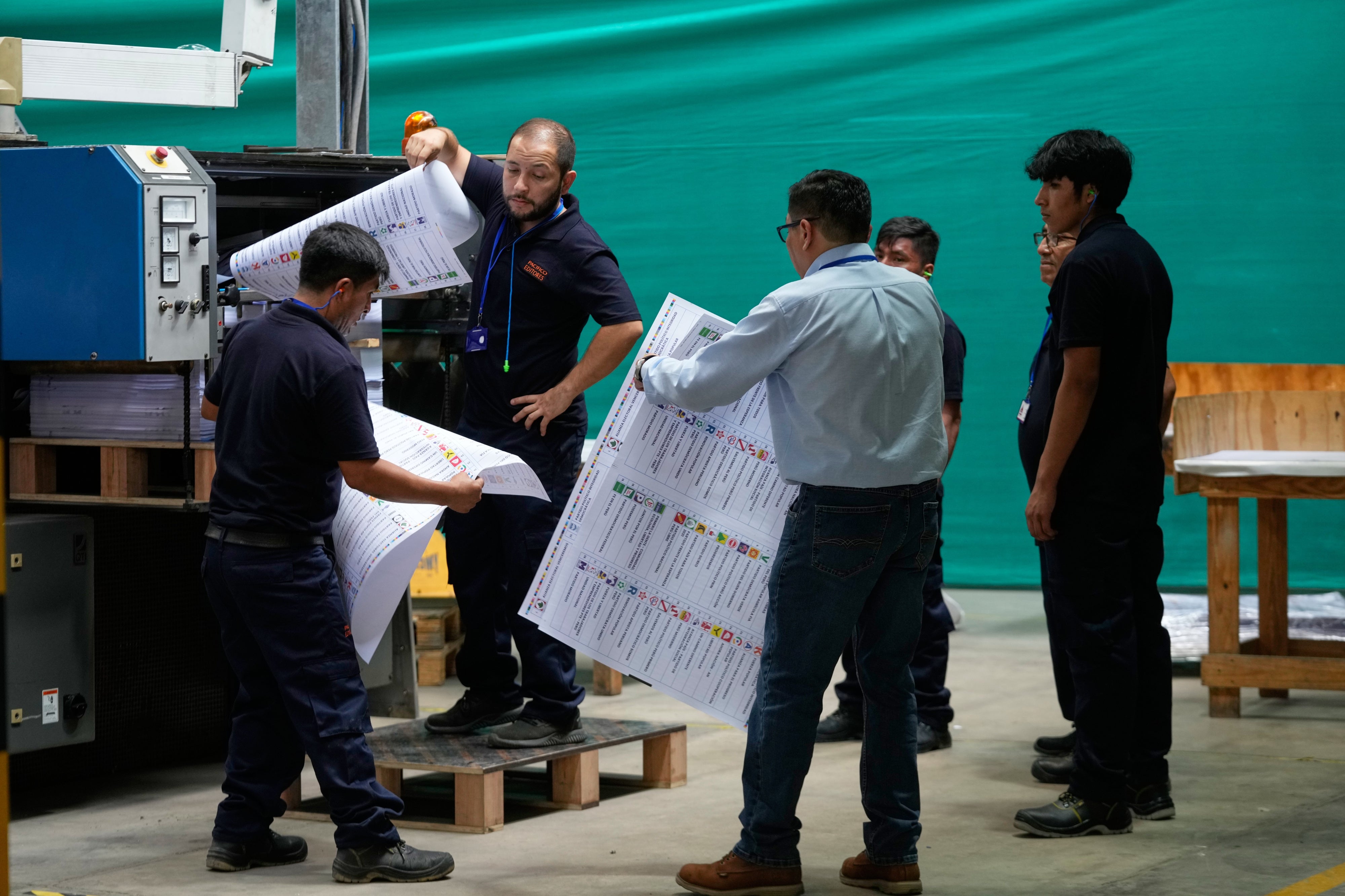 Electoral workers inspects a color test of newly printed ballots ahead of the presidential election, during a media presentation in Lima, Peru, Tuesday, March 10, 2026.