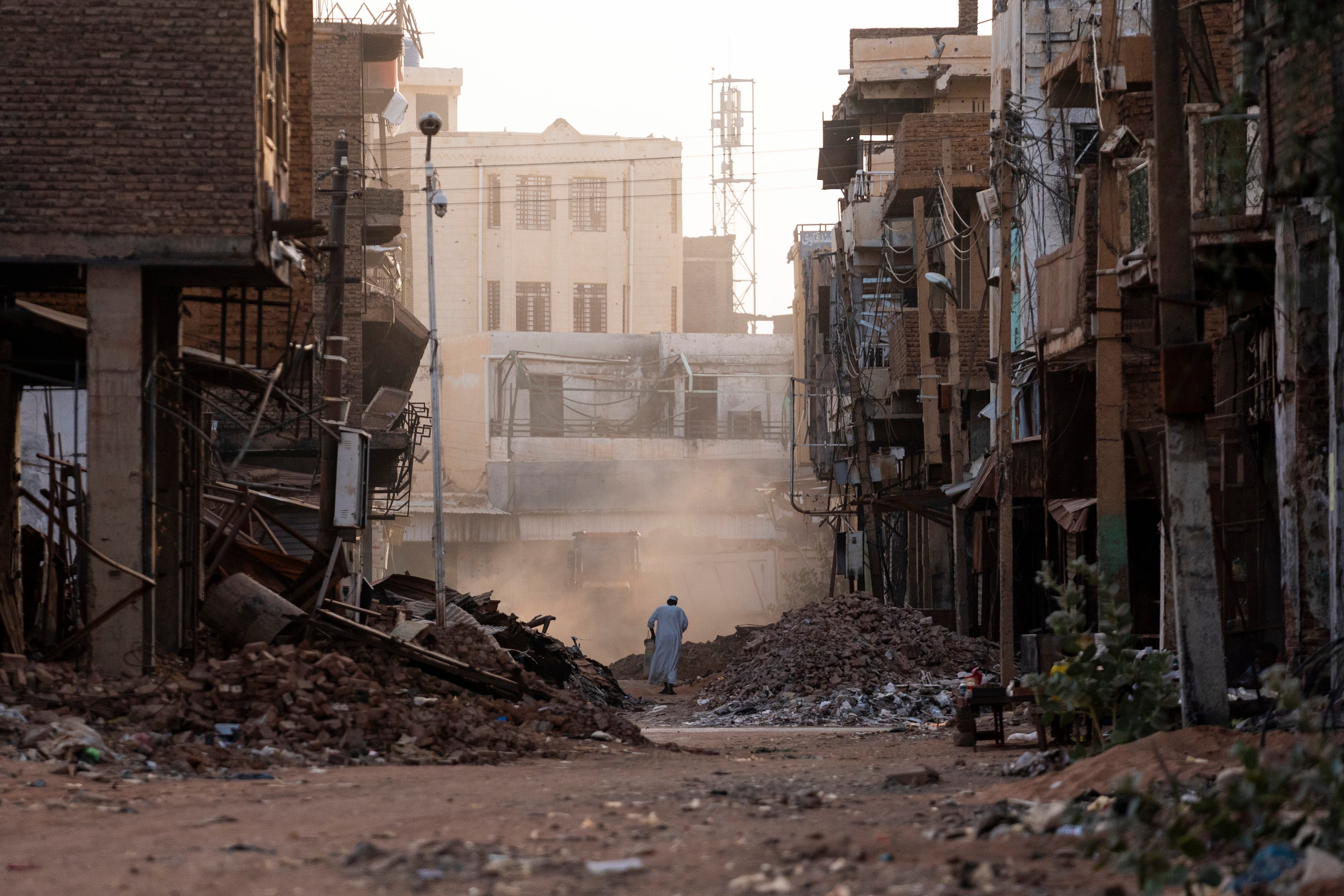 People pass through a destroyed section of Omdurman, Sudan on May 25, 2025. 