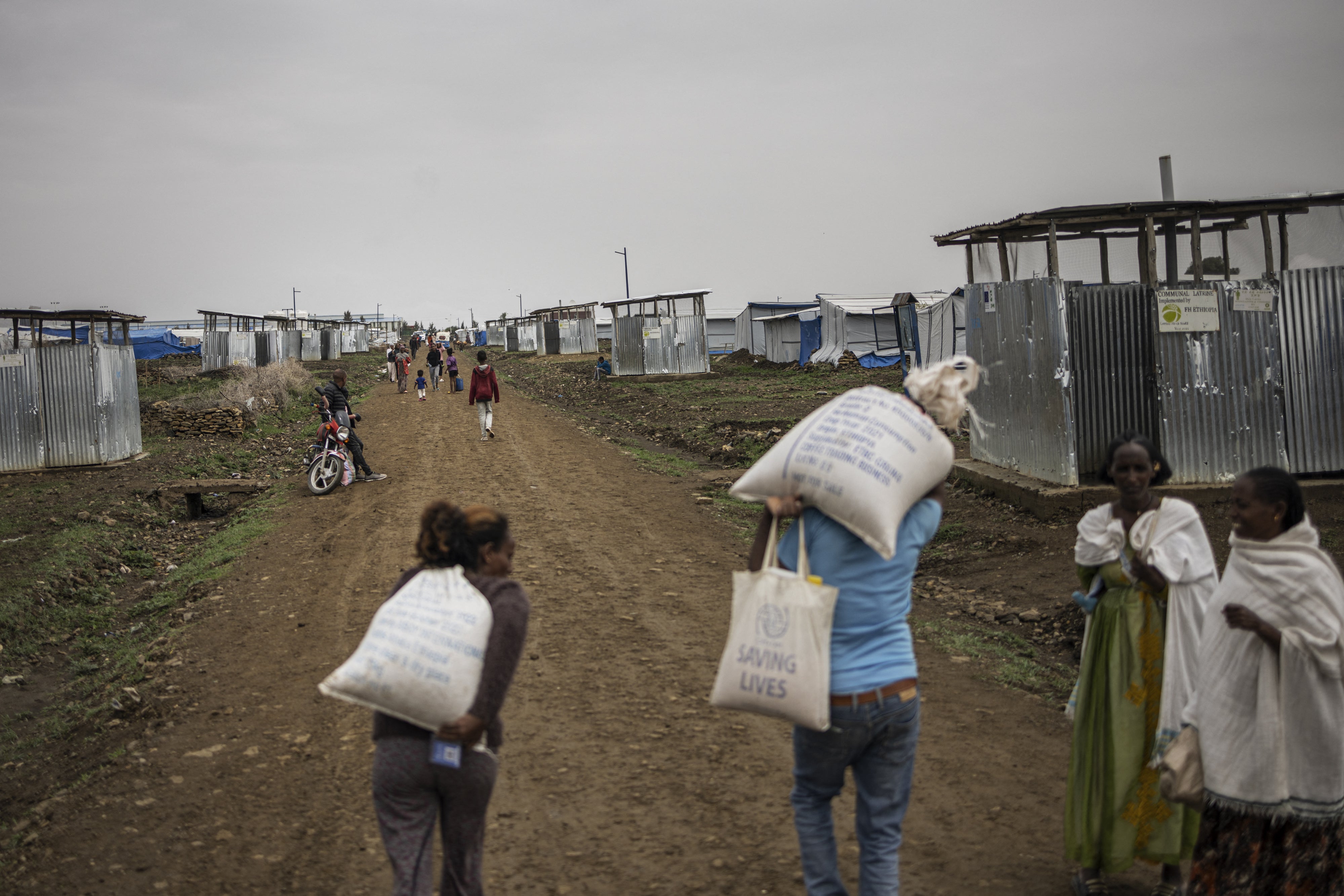 Internally displaced people carry food parcels during a distribution at Seba Care displaced persons camp in Mekelle, Tigray region, Ethiopia, July 19, 2024.