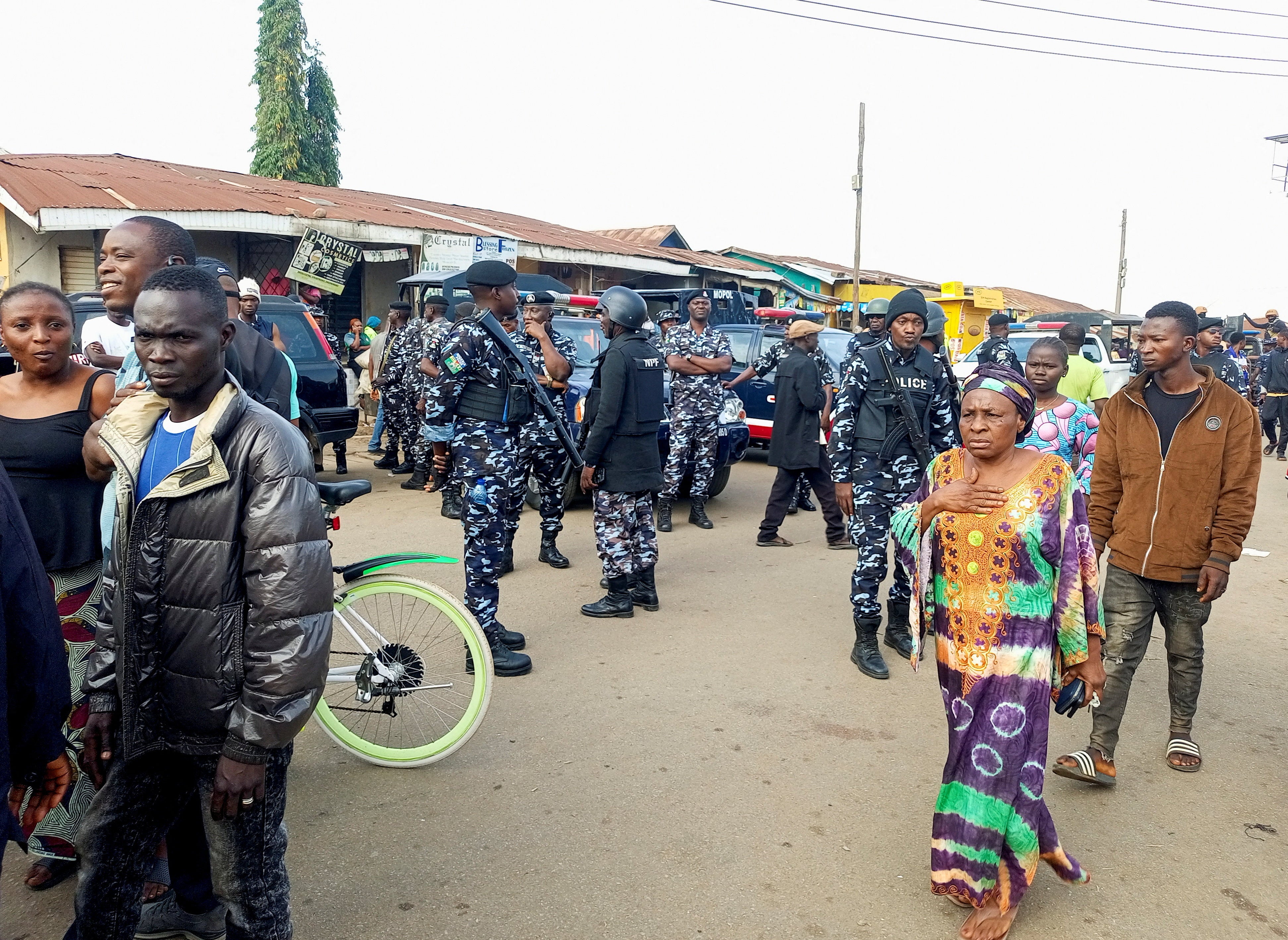 People gather as Nigerian policemen arrive at the scene the morning after gunmen killed multiple people in an overnight attack in Angwan Rukuba, Jos North, Plateau State, Nigeria, March 30, 2026. 