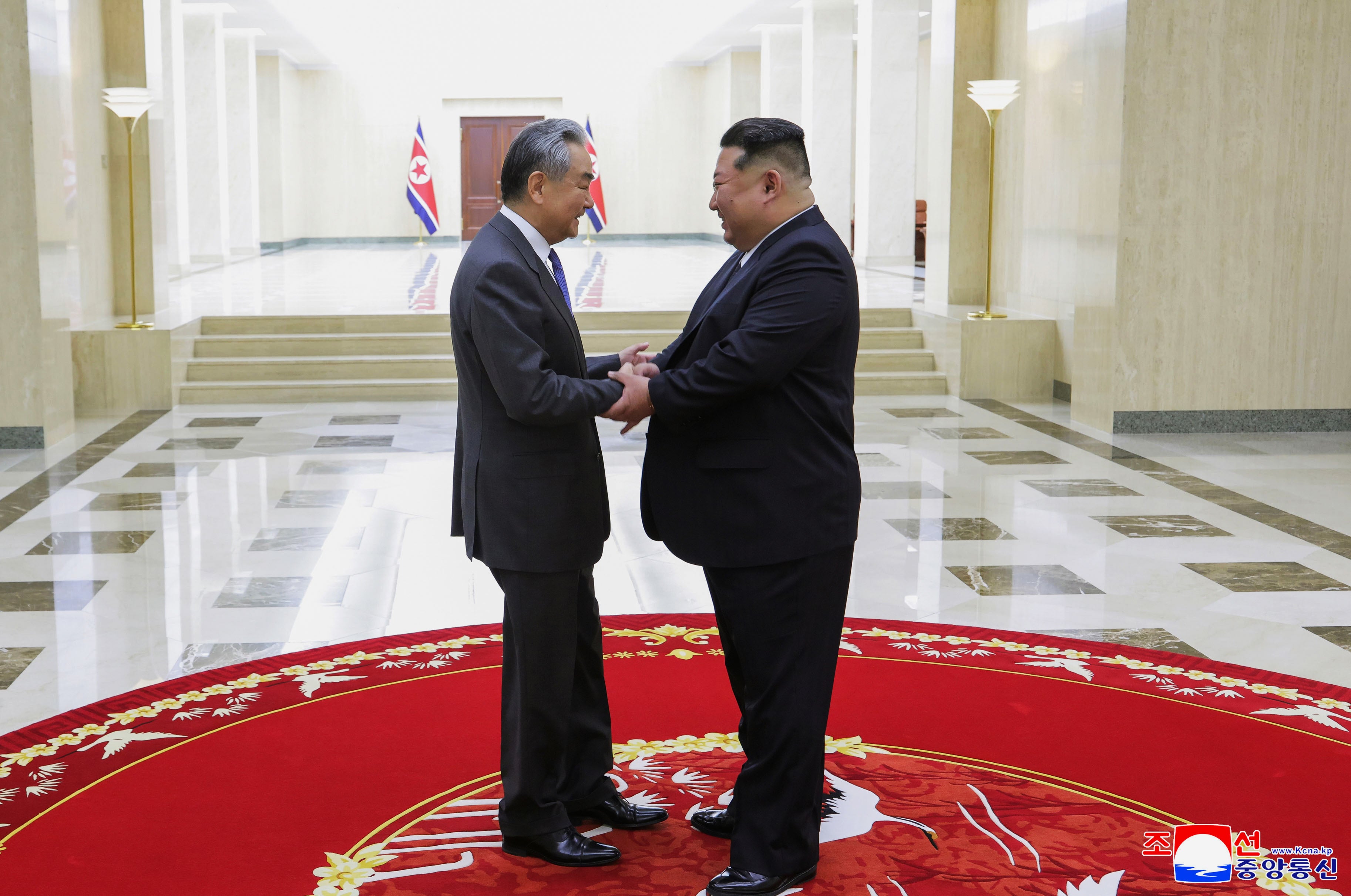 North Korean leader Kim Jong Un (right) greets Chinese Foreign Minister Wang Yi in Pyongyang, North Korea, on February 10, 2026.
