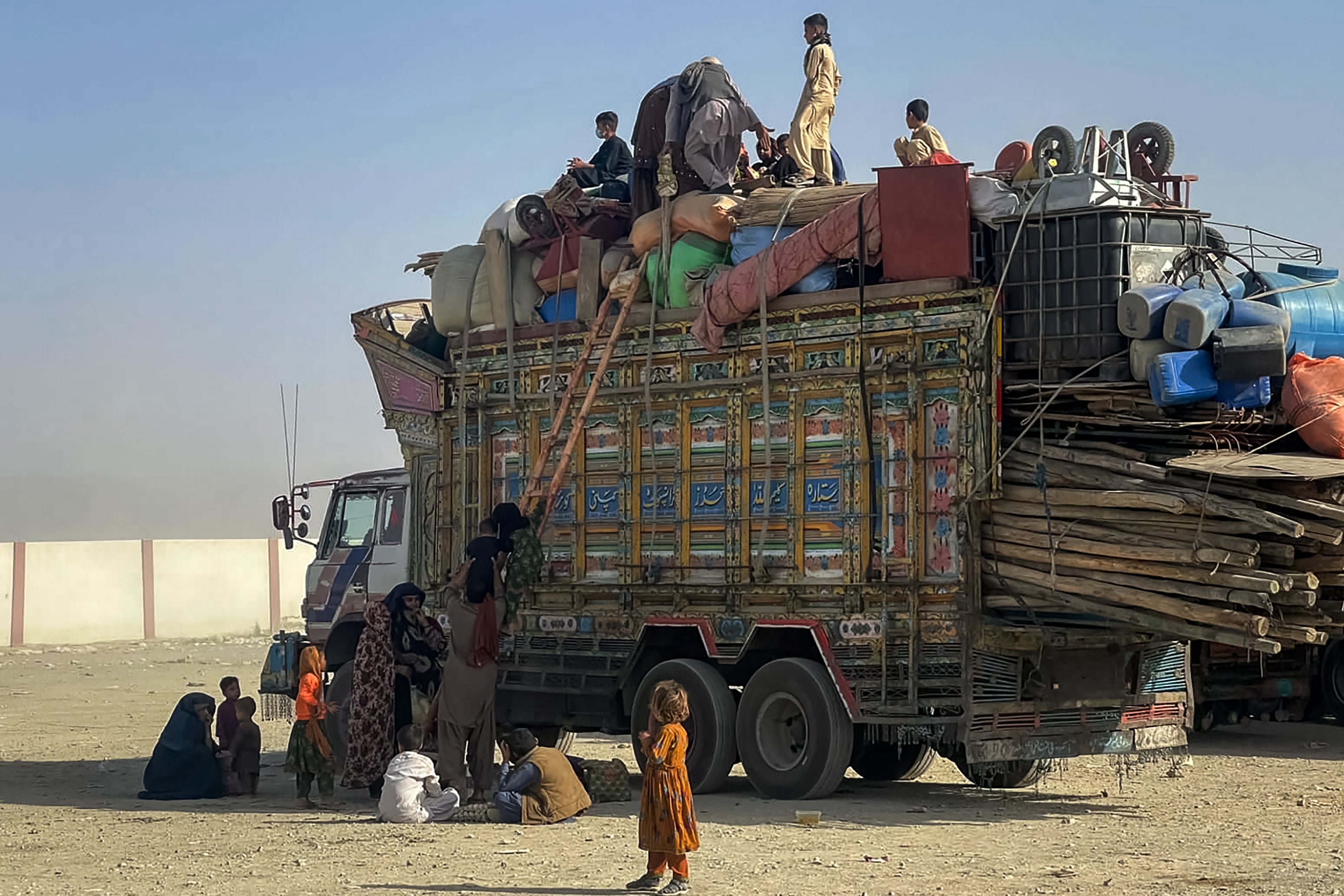 Afghan refugees board a truck with their belongings as they await deportation at the Pakistan-Afghanistan border in Chaman on October 19, 2025.