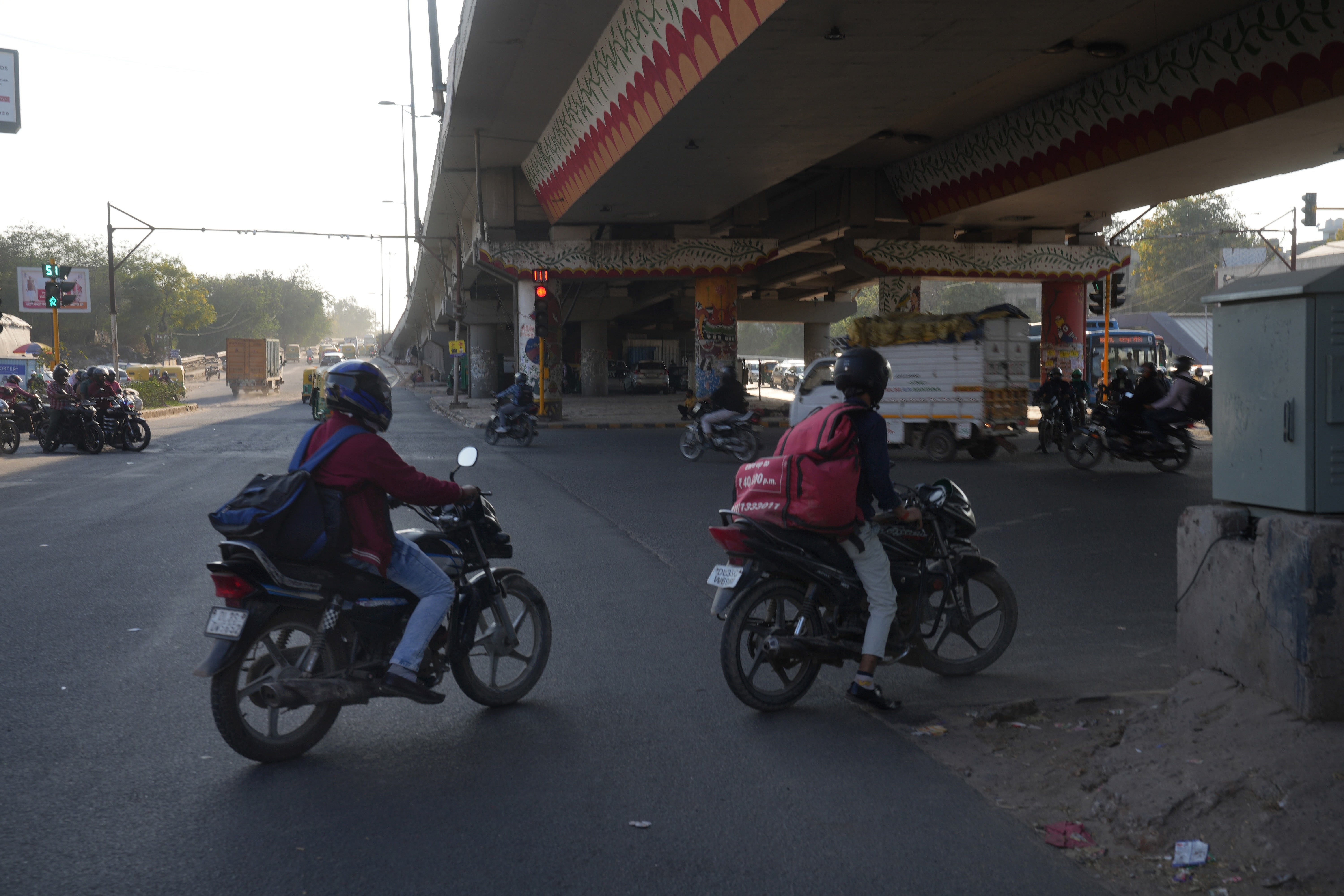 Delivery workers driving through New Delhi, India, 2026.