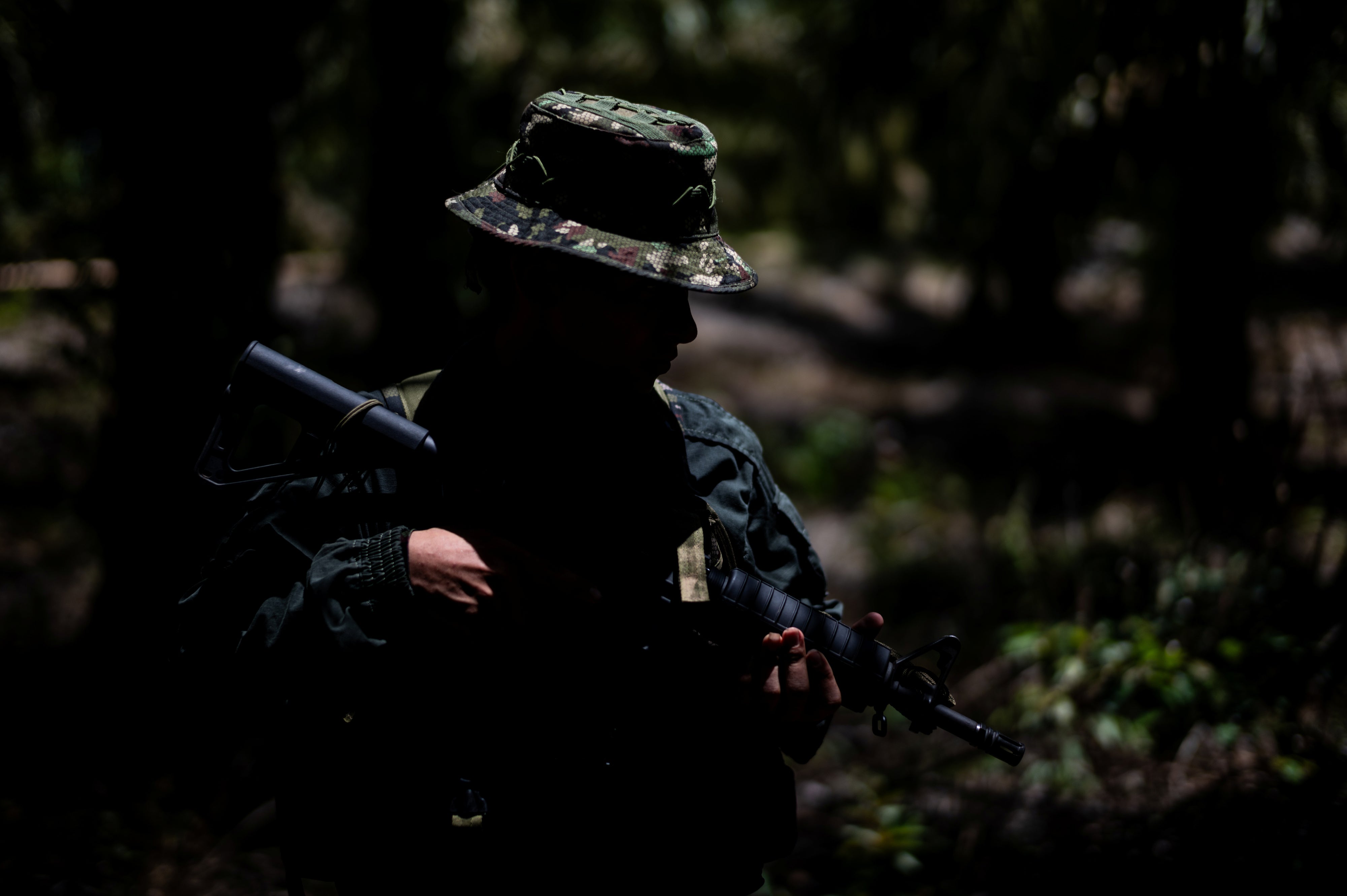 An unidentifiable child soldier holding a gun
