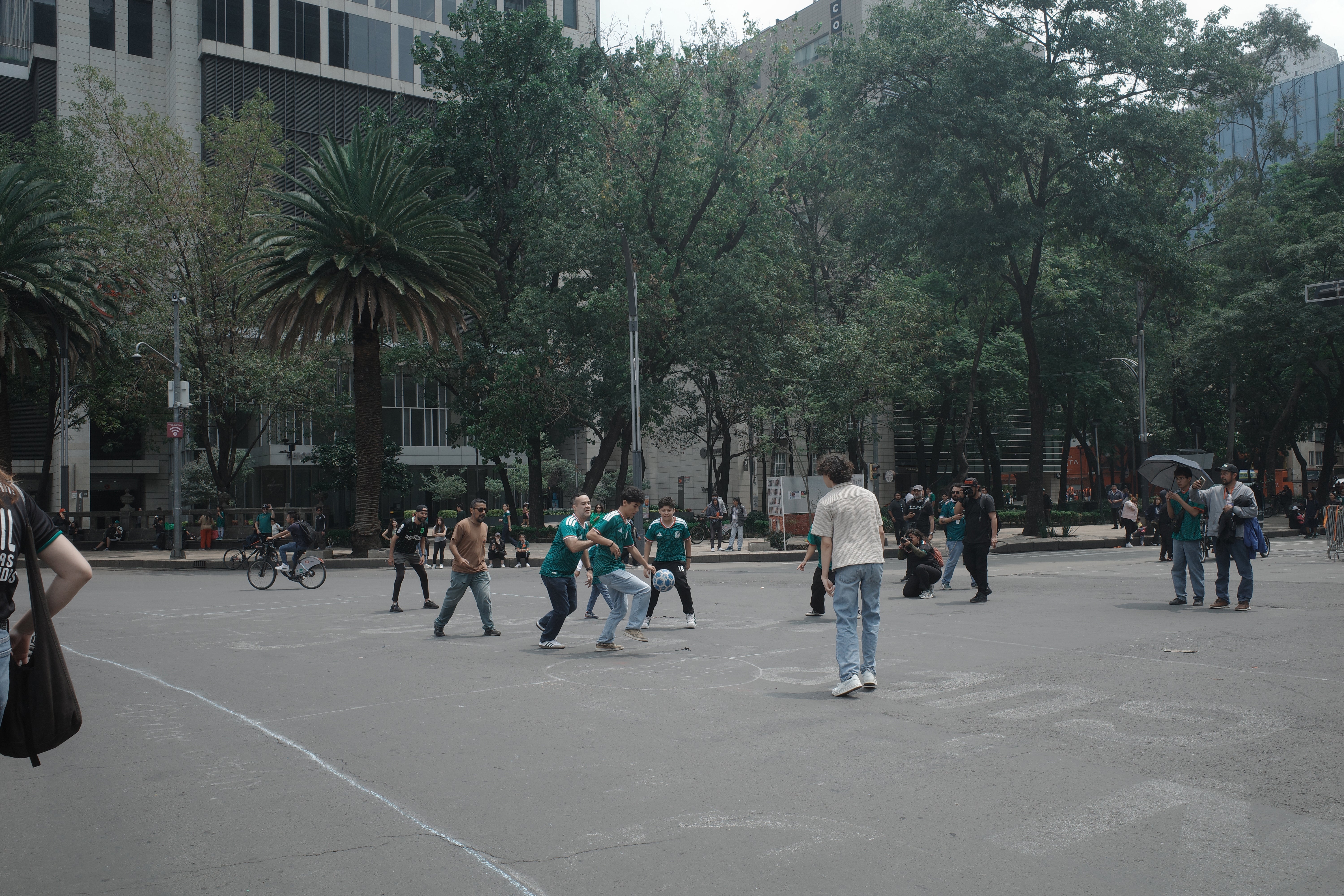 Passersby take part in a pickup football game organized by civilian search collectives on Mexico Citys Paseo de la Reforma during the World Cup, July 2026.